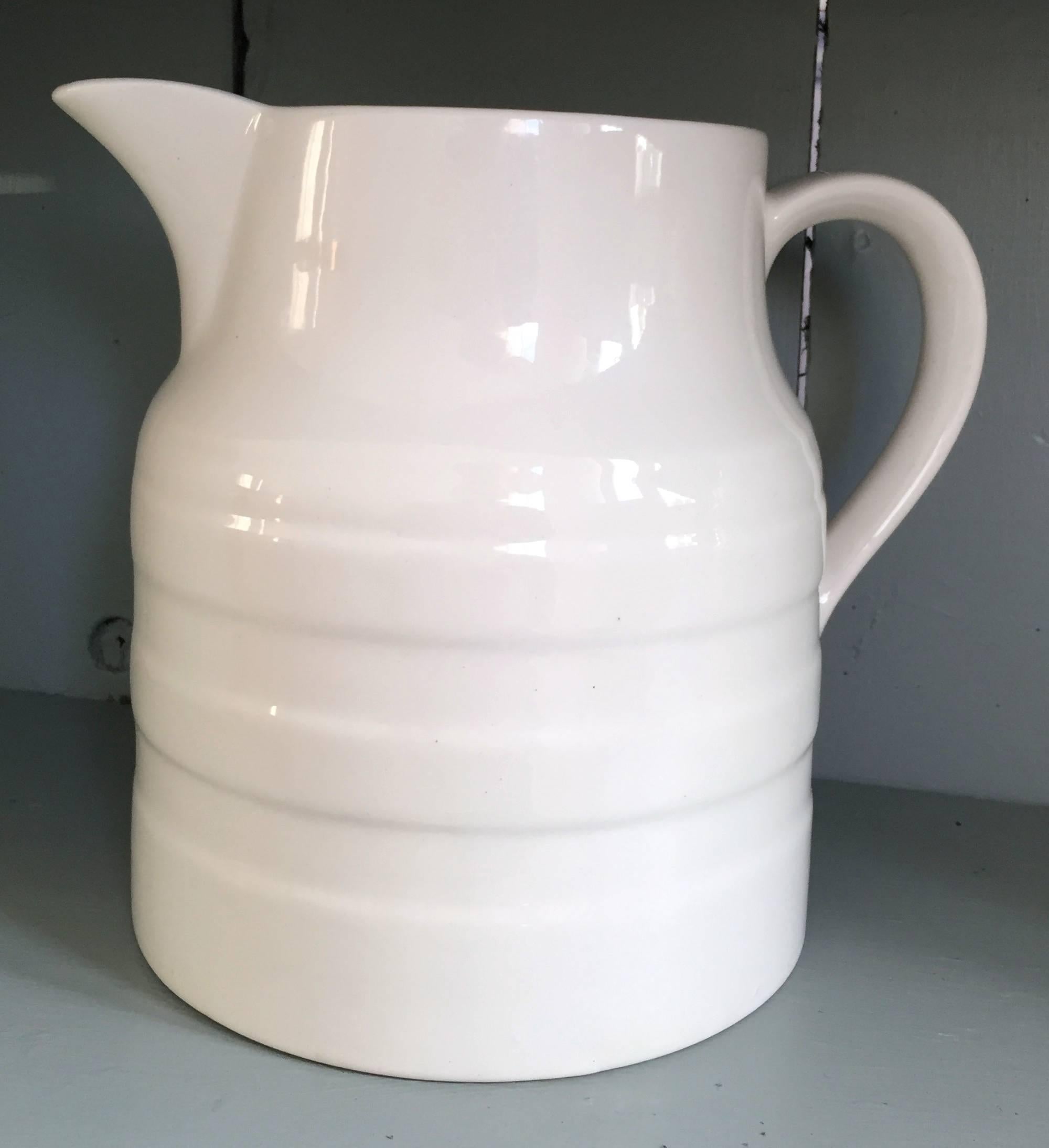 Graduated set of four English white ware ceramic milk dairy jugs banded ribbed design. The sizes are as follows 

18.5 cm.
17 cm.
14.5 cm.
12.5 cm.