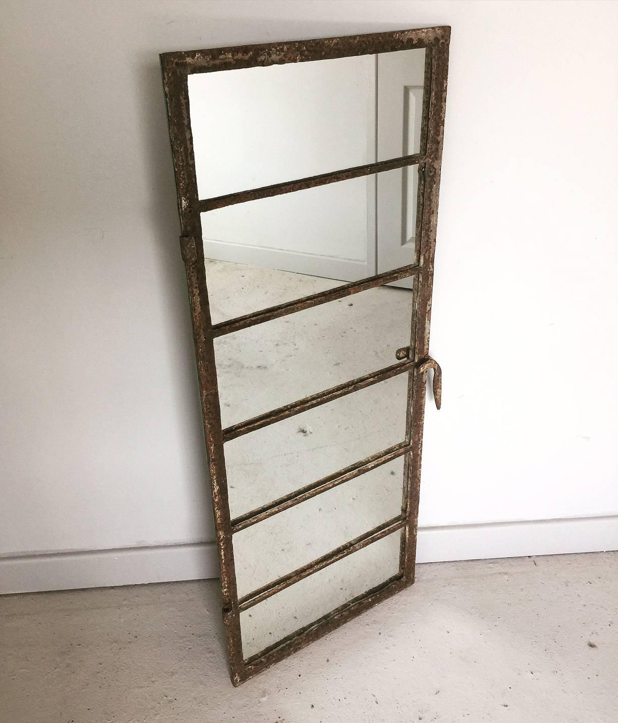 Vintage French cast iron window frame converted in to a mirror and retaining its original hinges and handle .