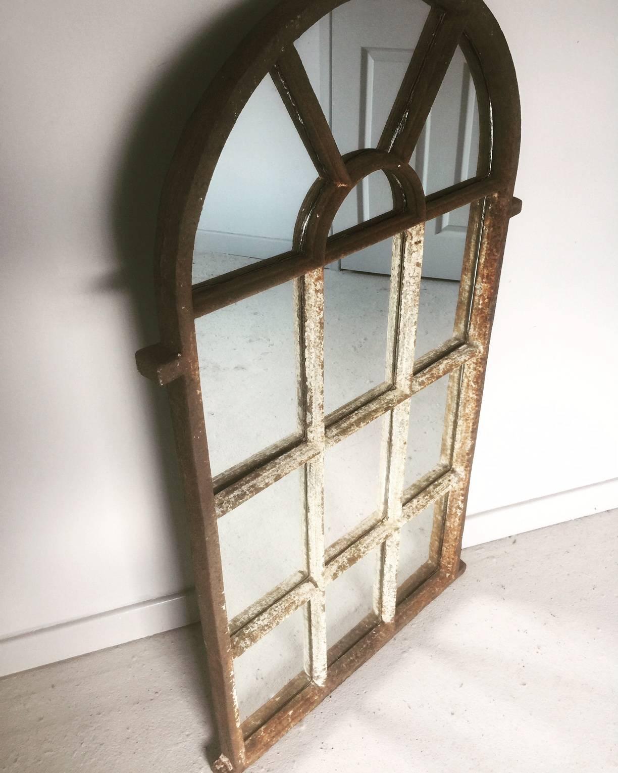 Antique architectural arched top cast iron window frame mirror. This cast iron window frame from a railway cottage in Yorkshire has been converted in to a mirror with the remains of old paint still visible and a natural aged patina suitable for