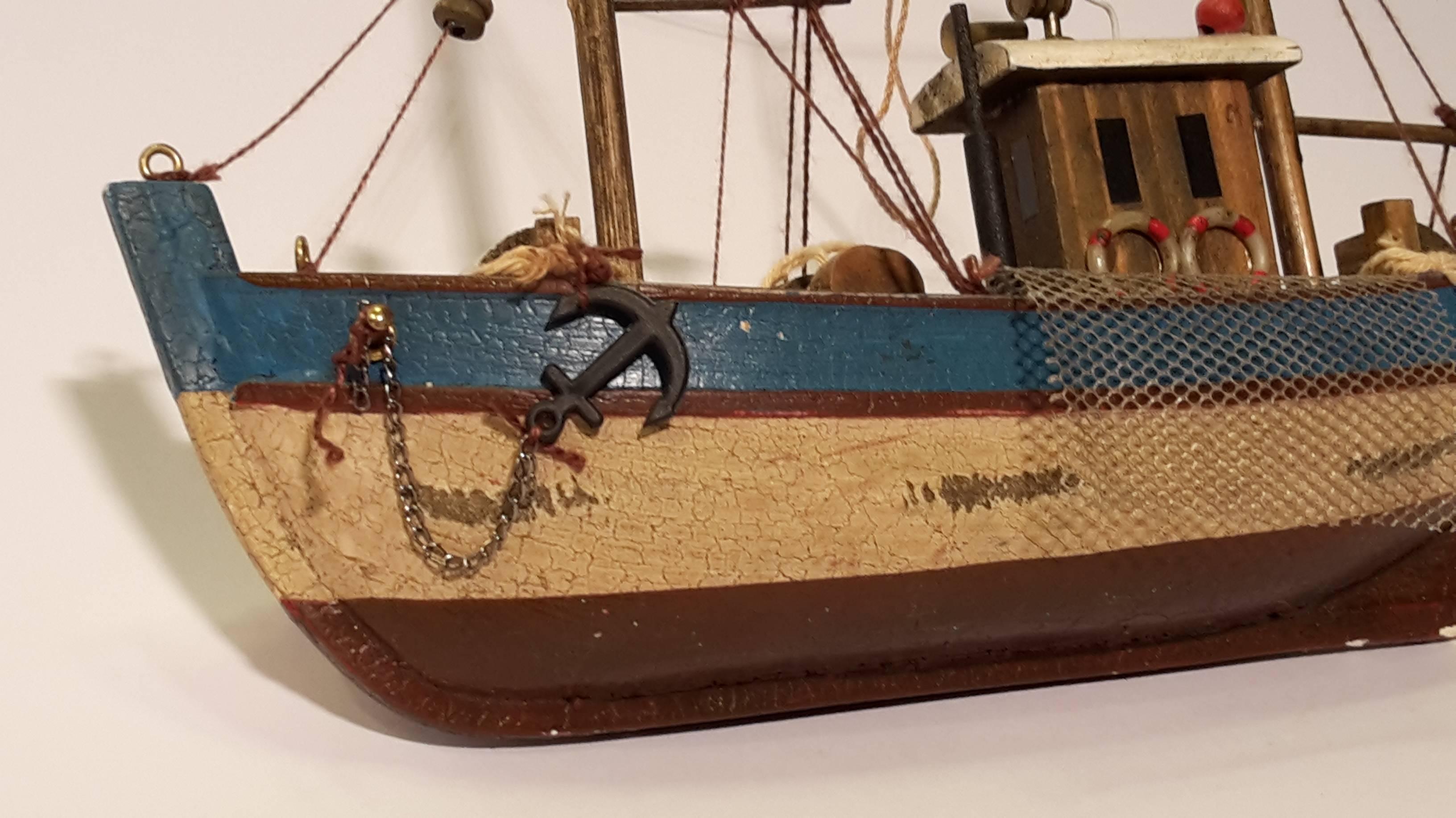 Small sculpture of a fishing vessel. 
Painted wood, beautiful details (the network to collect the fish, rudders), French, modern, can hang it. 
To add to your collection.