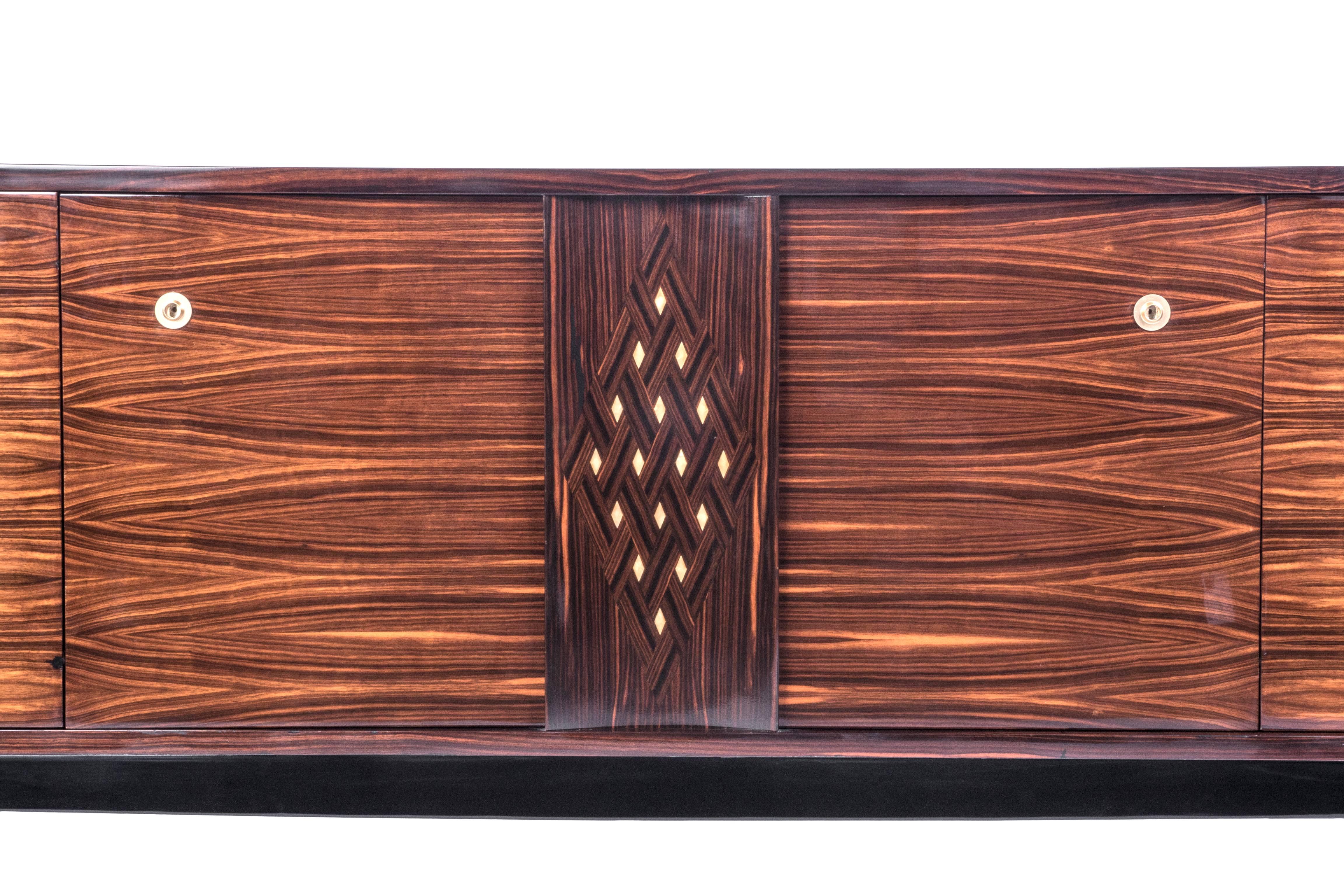 Rare French Art Deco in blonde Macassar ebony veneered mahogany buffet / sideboard with interiors in sycamore. The pieces have a geometric design inlaid on the center panel what gives it a modern feel.