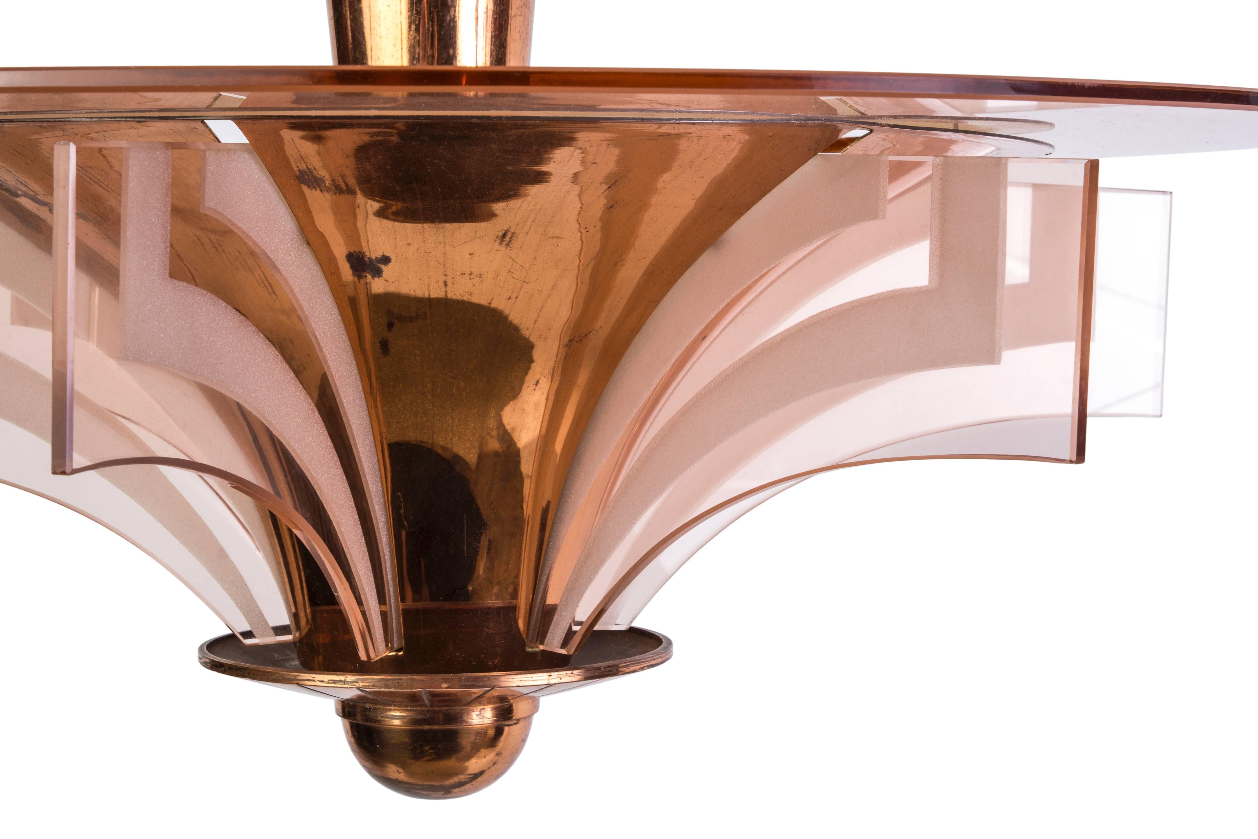 Dieser atemberaubende französische Art-Déco-Kronleuchter von Petitot ist trompetenförmig und besteht aus Kupfer und lachsfarbenen Glasakzenten und -platten.
 