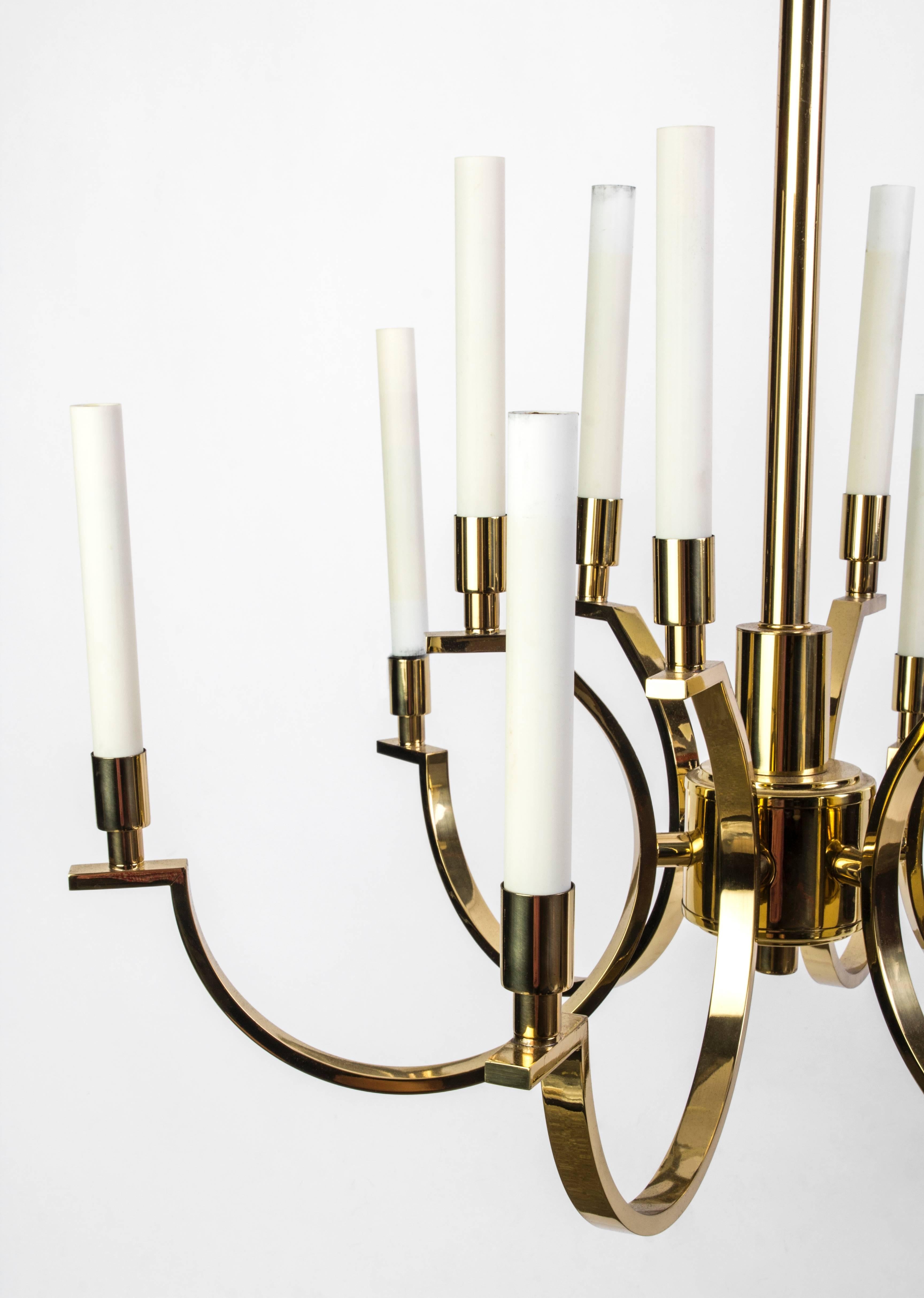 This exquisite Mid-Century Modernist chandelier was designed by Frederick Cooper. It features a two-tier brass frame candelabra form design with elongated candlestick lights. It is in excellent condition.
 