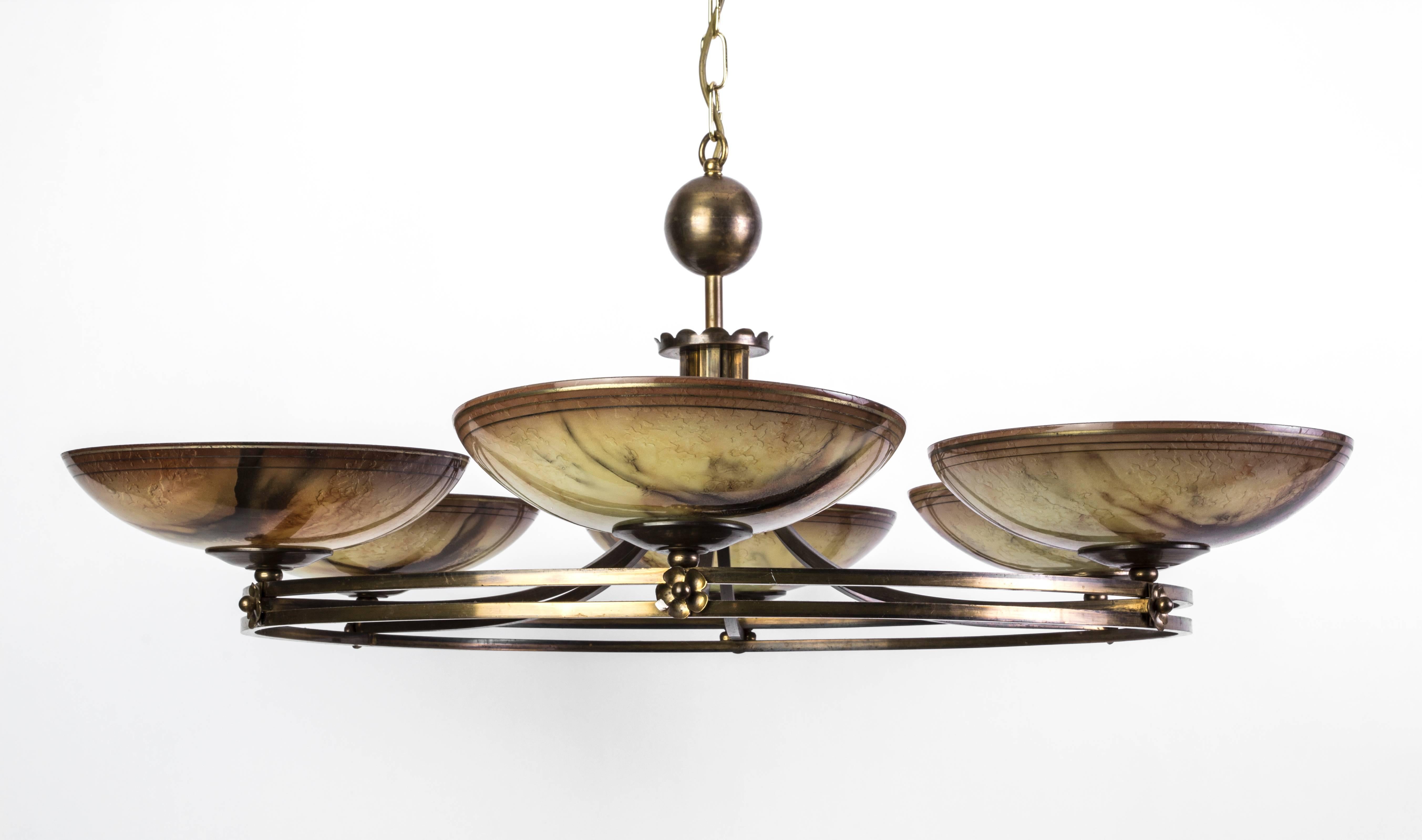 This unique German Art Deco chandelier was designed by Ikora. It features a gilded wrought iron frame with six glass shades in hues of umber and pearl.