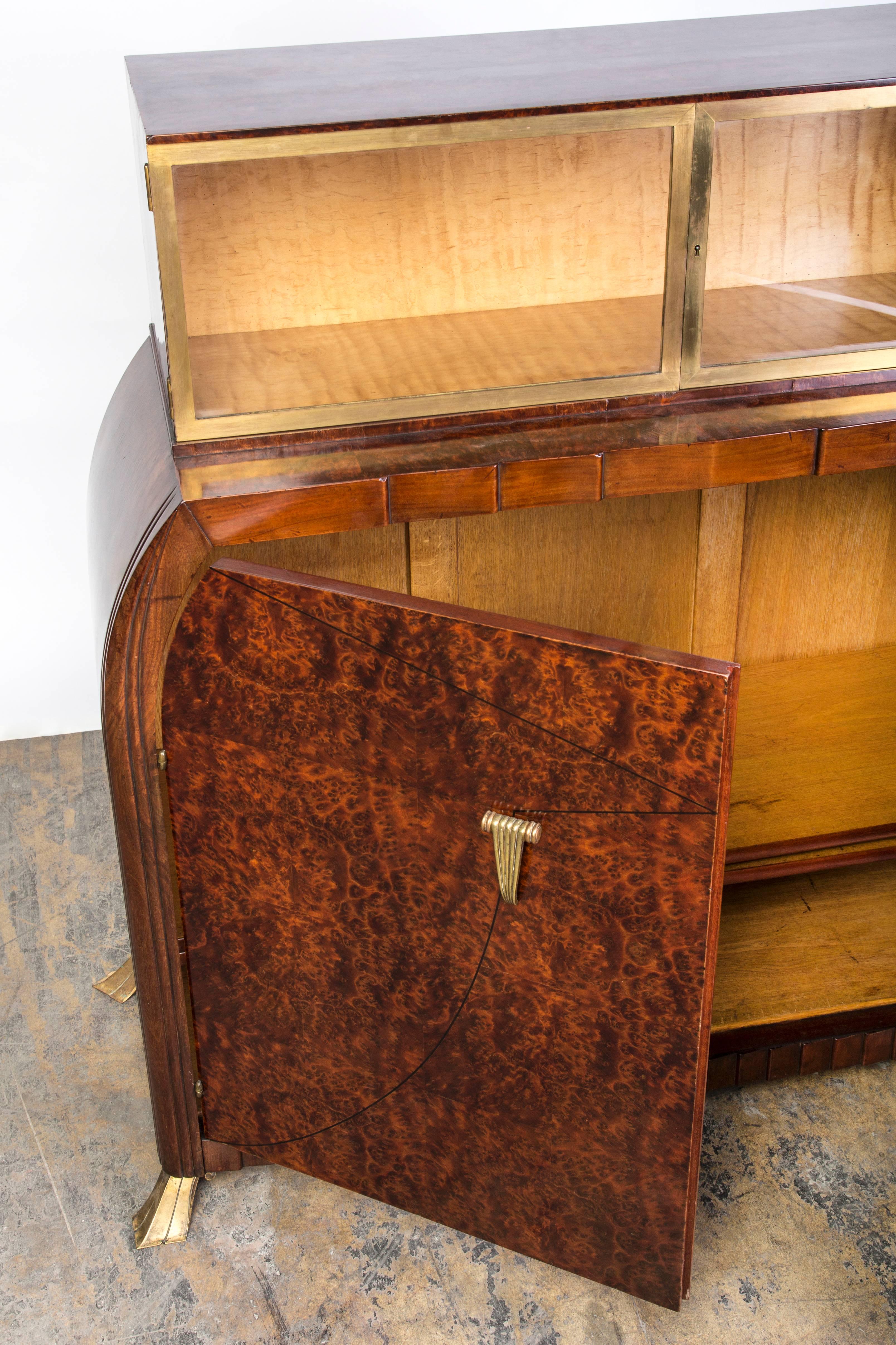This exquisite signed Art Deco sideboard/dresser by Roger Bal is a one of a kind. It features a beautiful bookmatched mahogany burl and detailing in ebony inlays on the doors. This piece has ample storage with bronze detailing accents on the doors