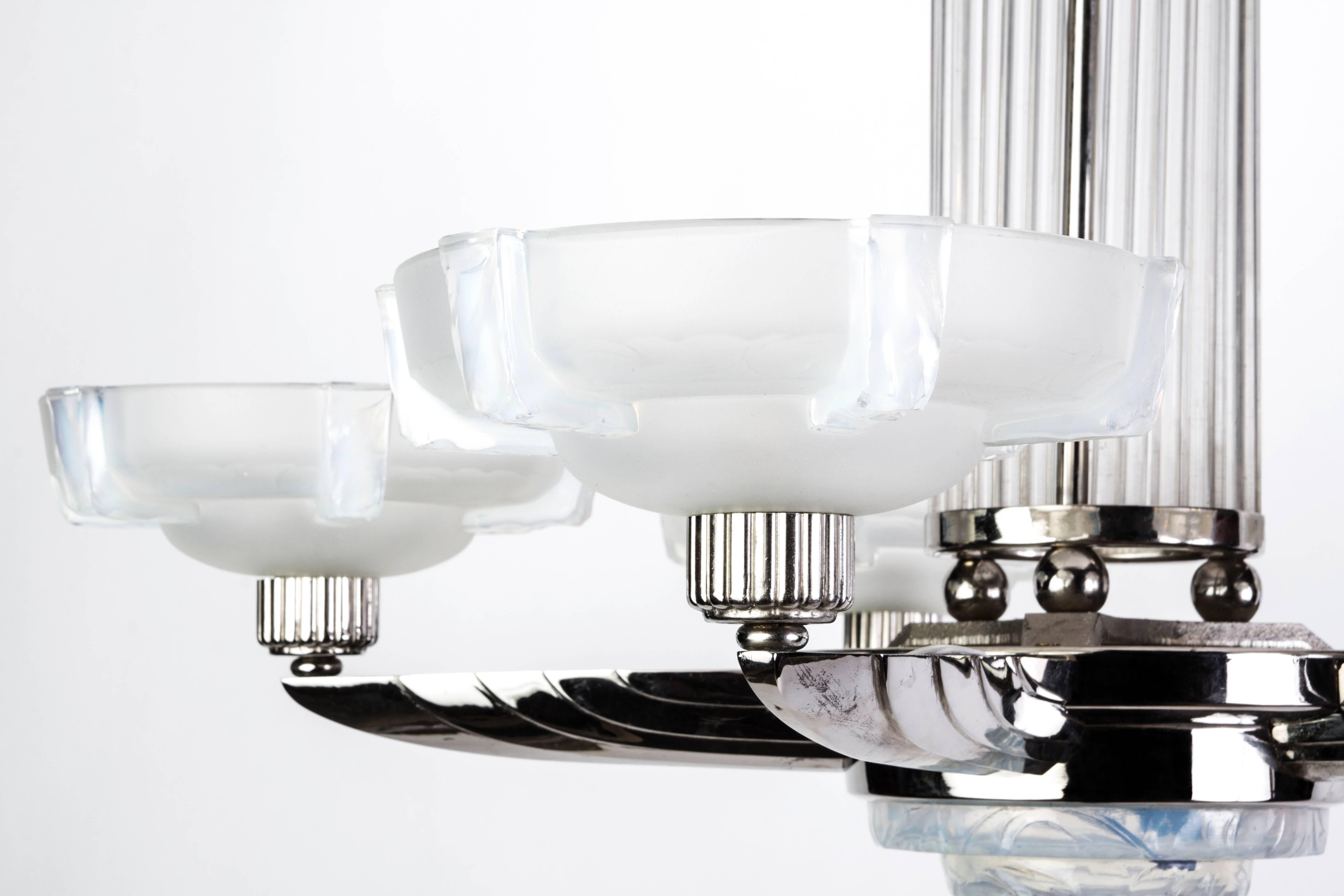 This stunning 1920s French Art Deco chandelier was designed and signed by Petitot. It features a nickel-plated frame with tubular glass rods with relief frosted opalescent glass shades.

