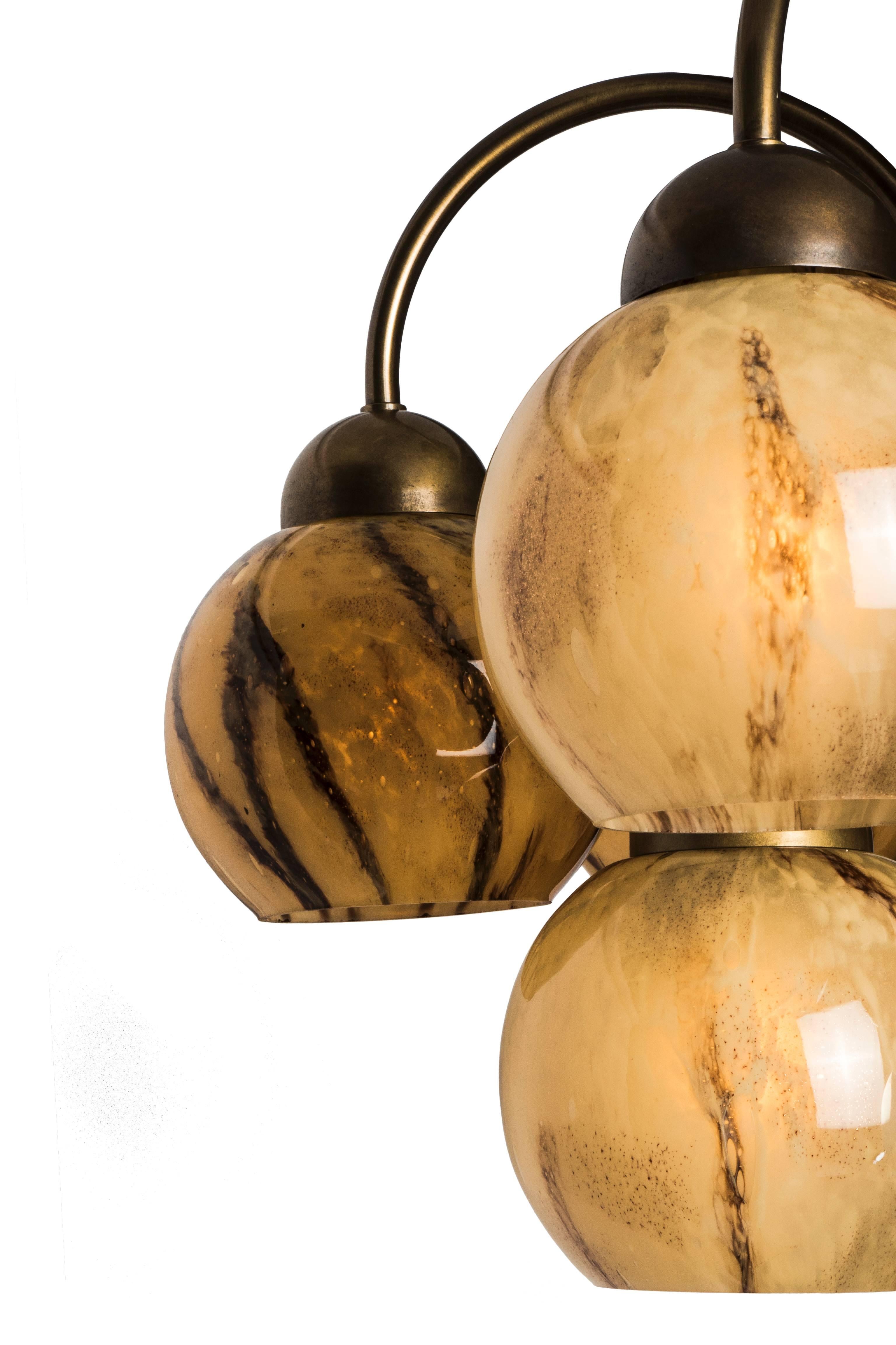 This beautiful Art Deco chandelier features a grape form design with a brass frame cascading to ten Murano glass globes in hues of pearl, sand and umber.

               