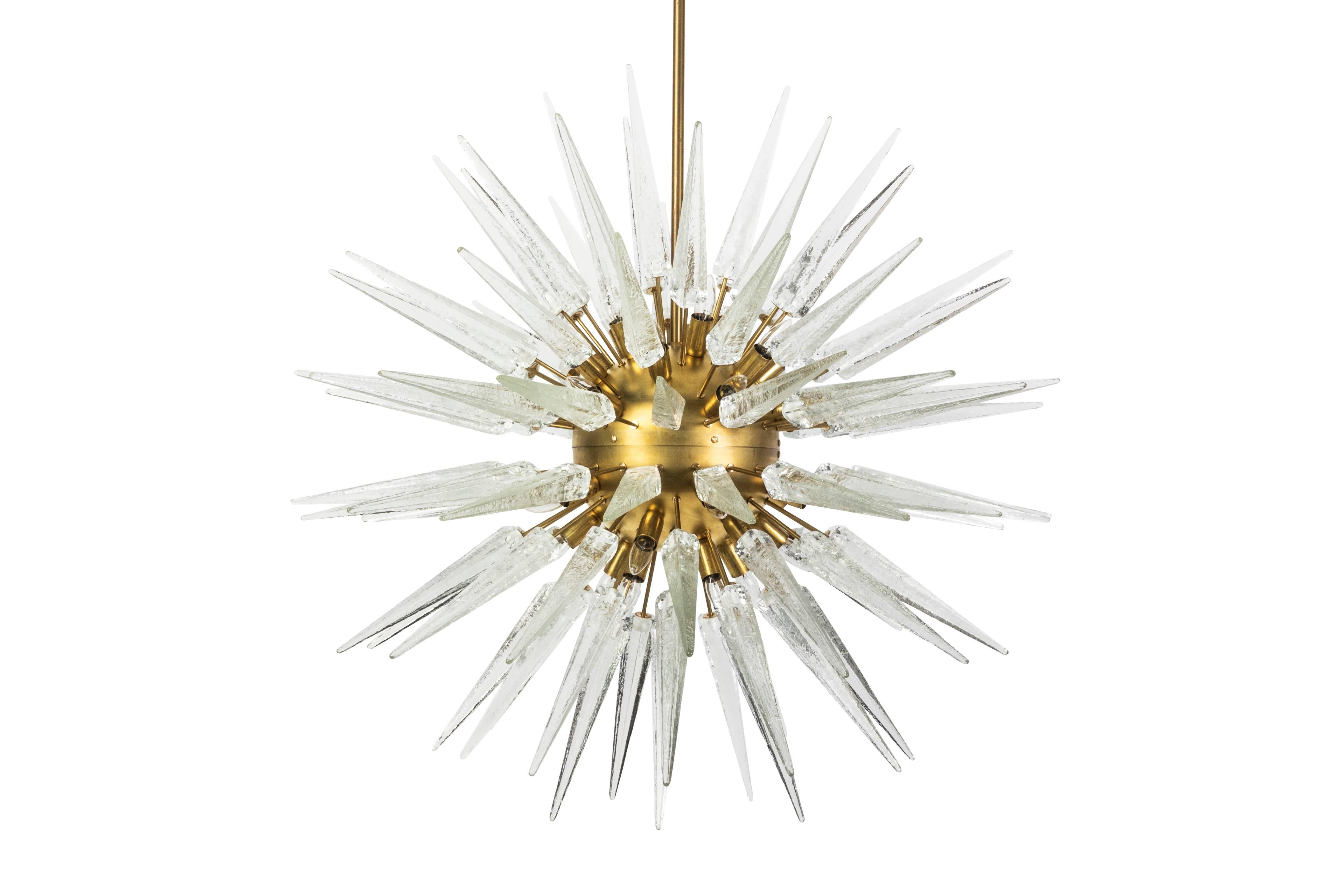 This magnificent Mid-Century Modernist style Sputnik chandelier features large textured Murano glass spikes (98) fixed directly to a large brushed brass central sphere with (29) standard base bulbs.