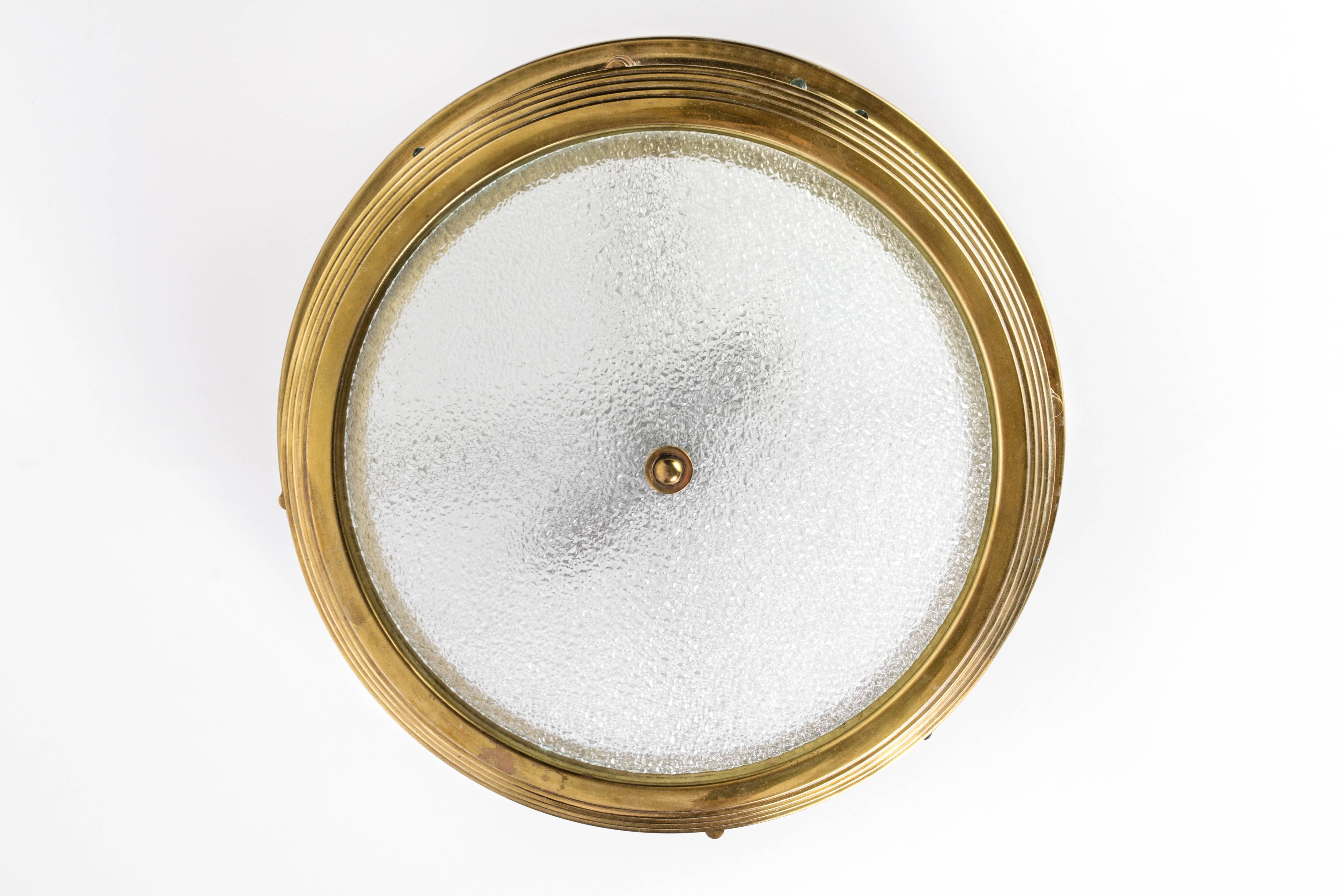This exceptional 1940s French Art Deco flush mount is attributed to Jean Perzel. It features a solid brass circular form with sides in clear glass rods and plate in pebbled glass. It is in excellent condition.