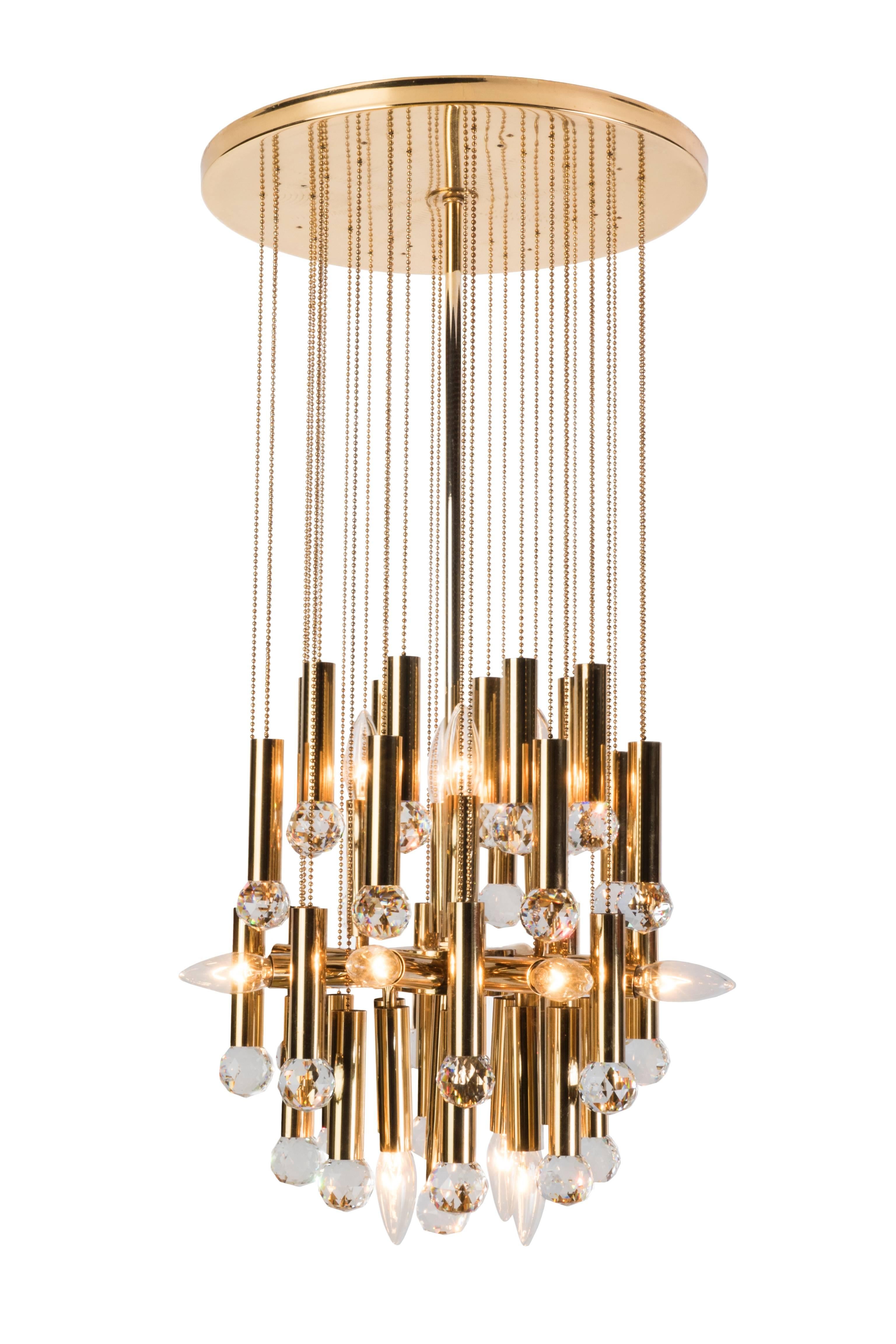 This stunning Ernst Palme Swarovski crystal and gilt brass chandelier features (16) lights encased in clear, handblown glass globe shades. The chandelier is in perfect, original condition and has been newly rewired.
 