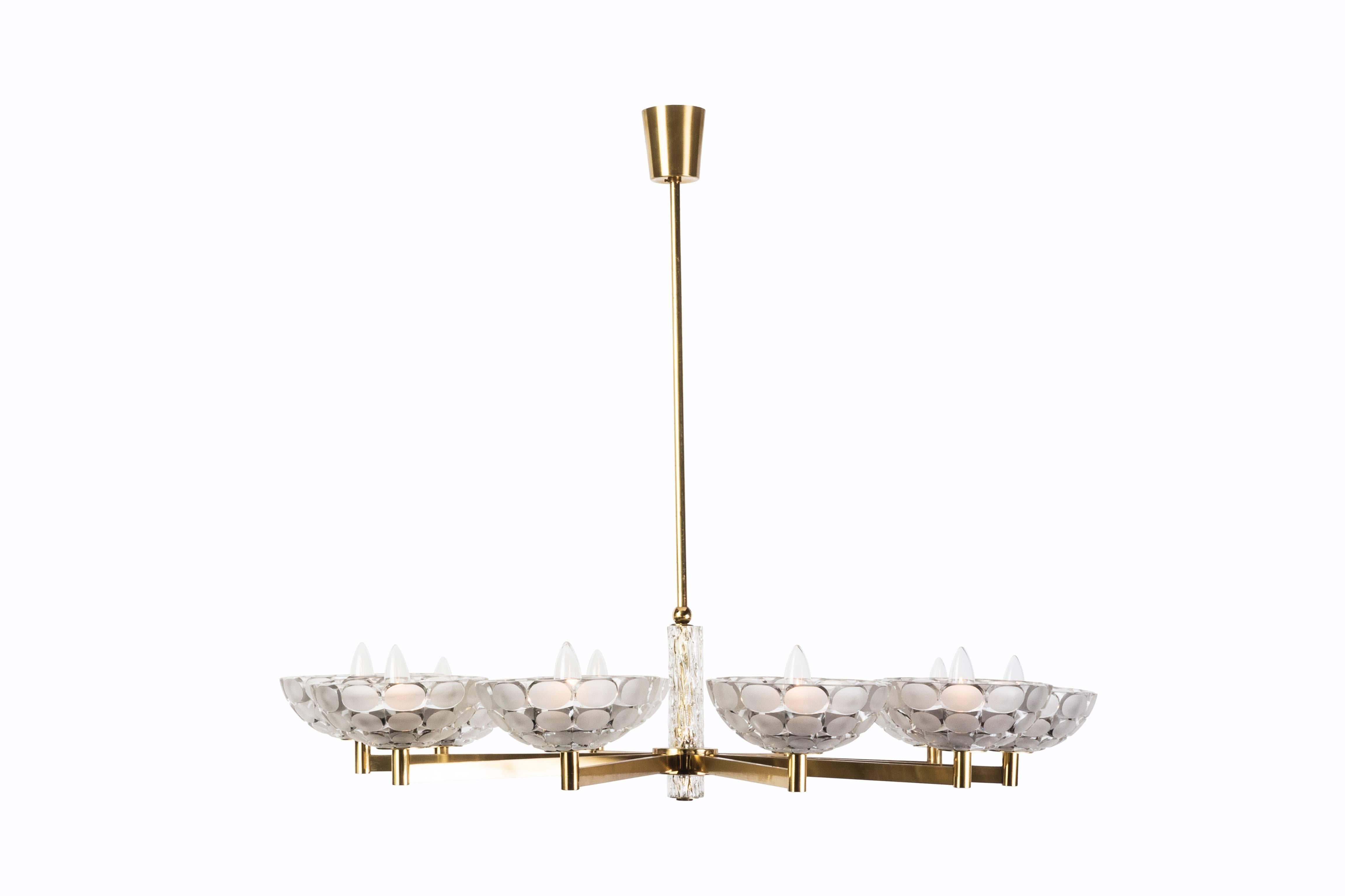 This gorgeous Austrian chandelier was executed by Kalmar and features a brass frame with frosted tubular glass detailing and ten relief frosted glass sconces with cut-outs in a frosted.

Made in Austria, circa 1950.

Measures: 38 3/4