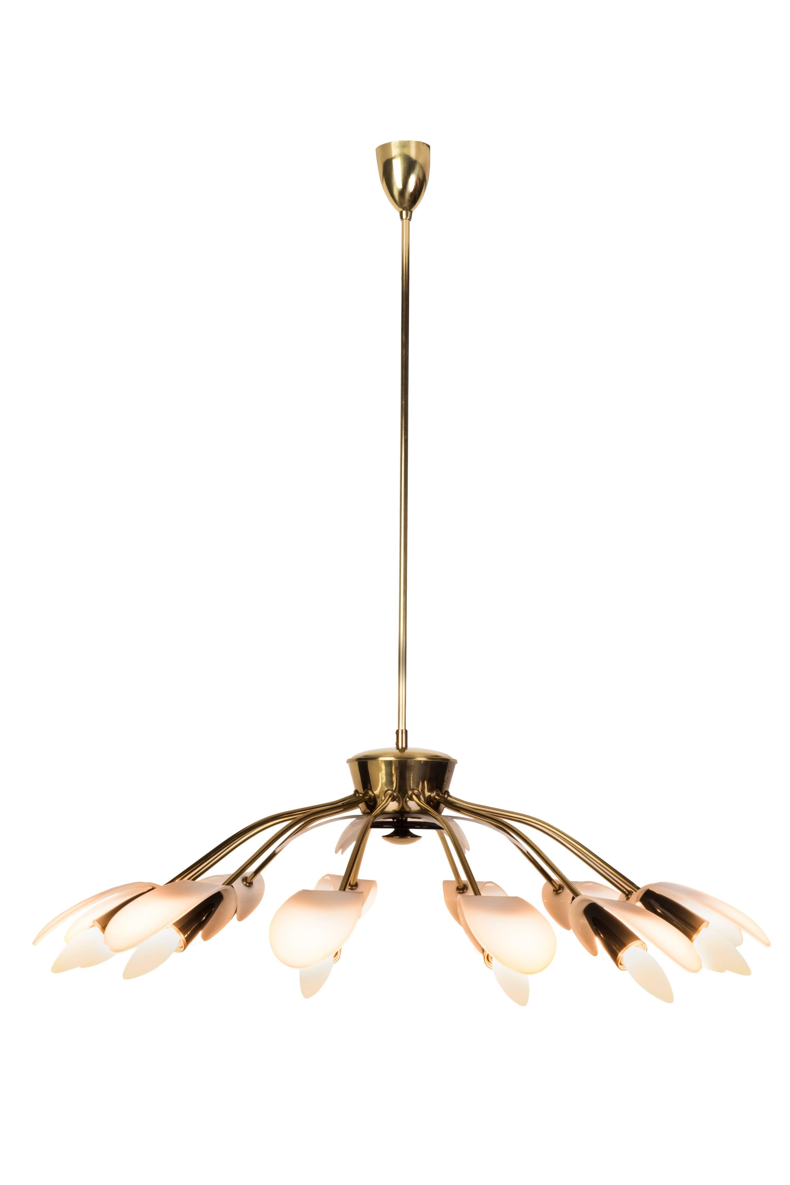 This exceptional 1950s Mid-Century modernist black spider twelve-light German sputnik chandelier pendant lamp is made out of a brass frame and Lucite shades and features exposed tulip bulbs. The chandelier is in excellent, original condition and is