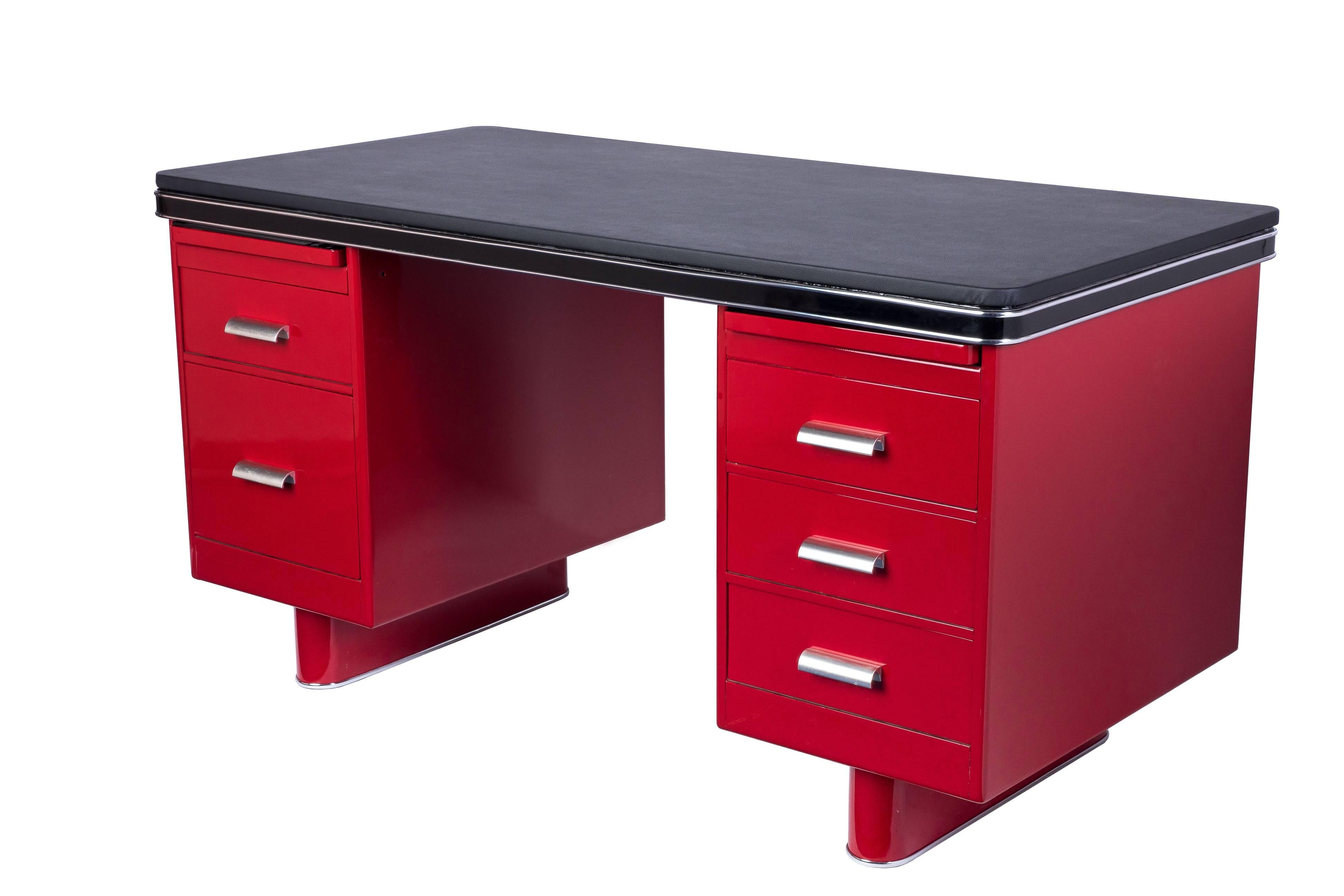 This wonderful turn of the 20th century metal desk was created by Bauhaus. It features chrome lines and fixtures with a high gloss lacquer in cherry and black leather top plate.