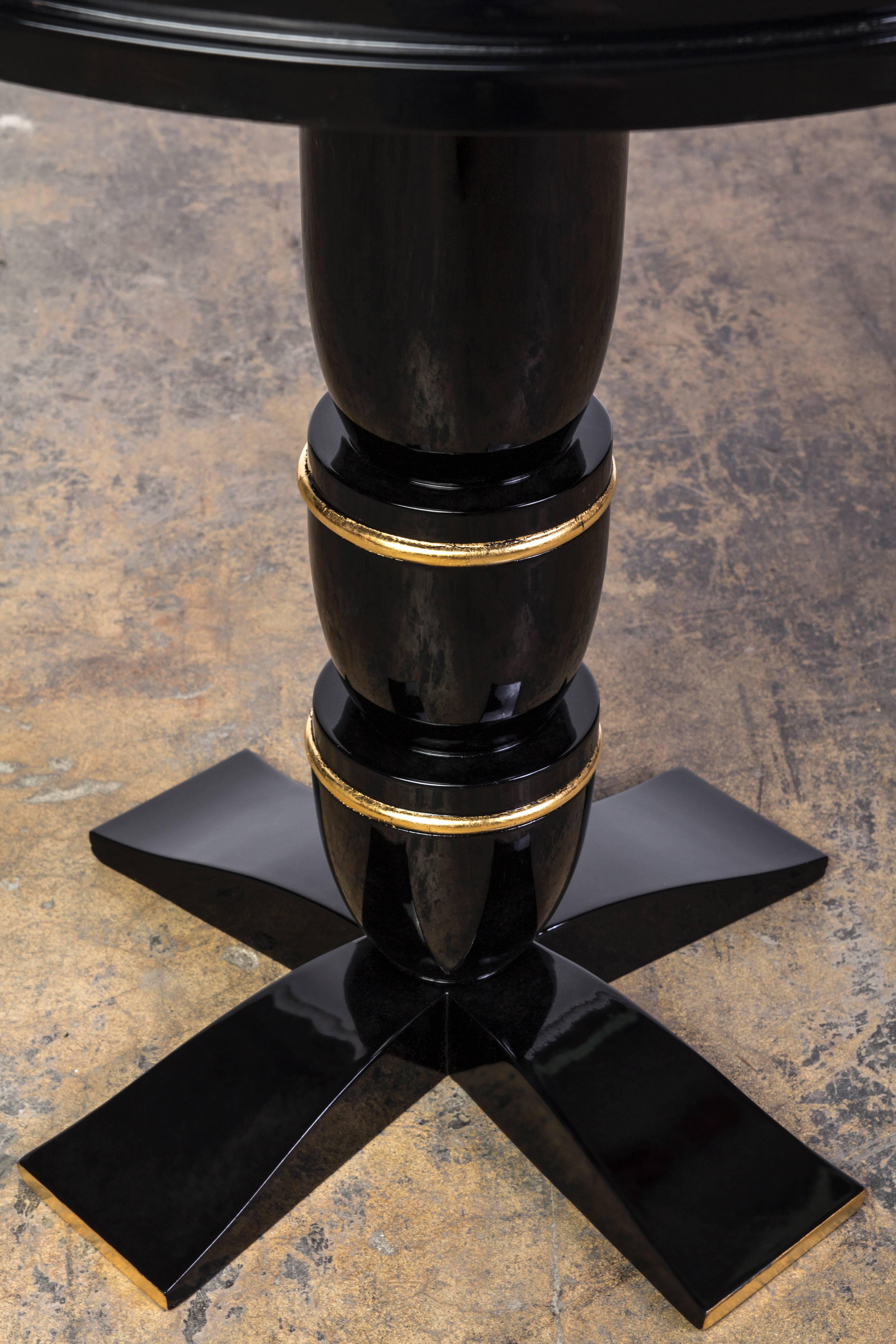 This unique Art Deco side / center table features a unique geometric design in red lacquer and gold leaf top, black lacquer finishing and gold leaf details.