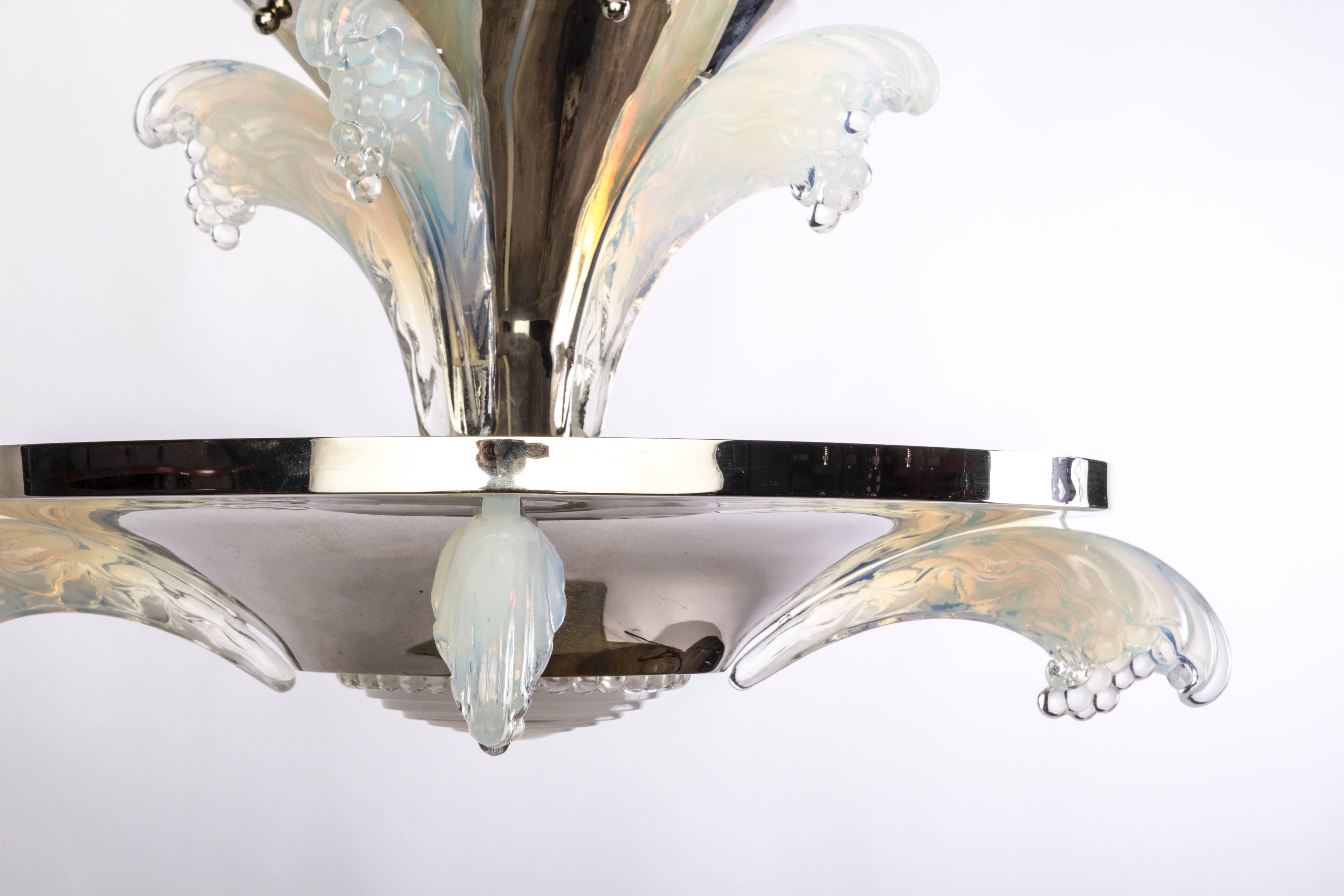This petit 1930s French Art Deco chandelier was designed and executed by Sabino. The frame has two (2) trumpet cascading tiers that is composed of nickel-plated metal and decorated with opalescent glass icicles.
 