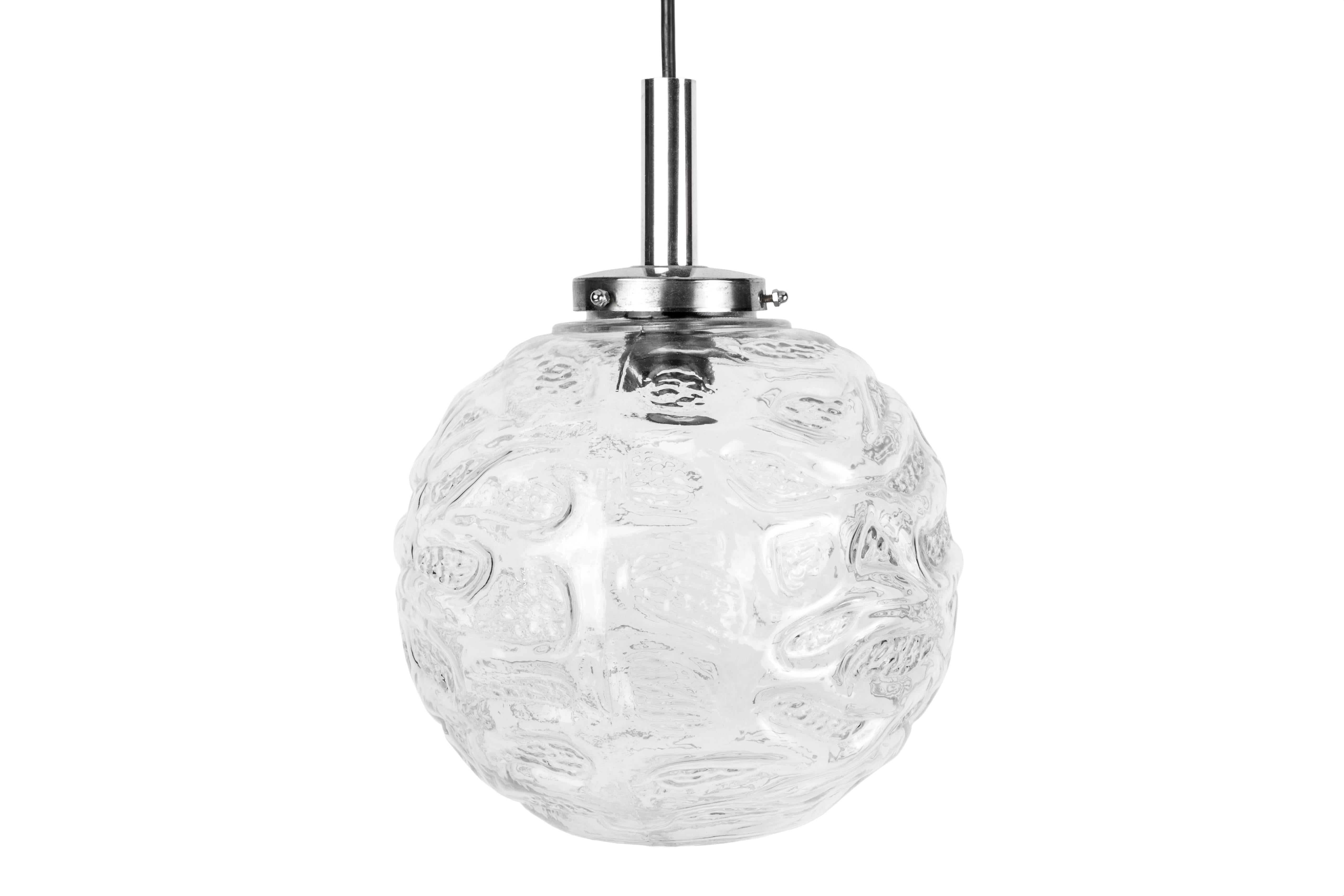 This impressive pair of Mid-Century Modernist pendants were designed by Doria. They feature a chrome base connected to glass circular globes with etched detailing.