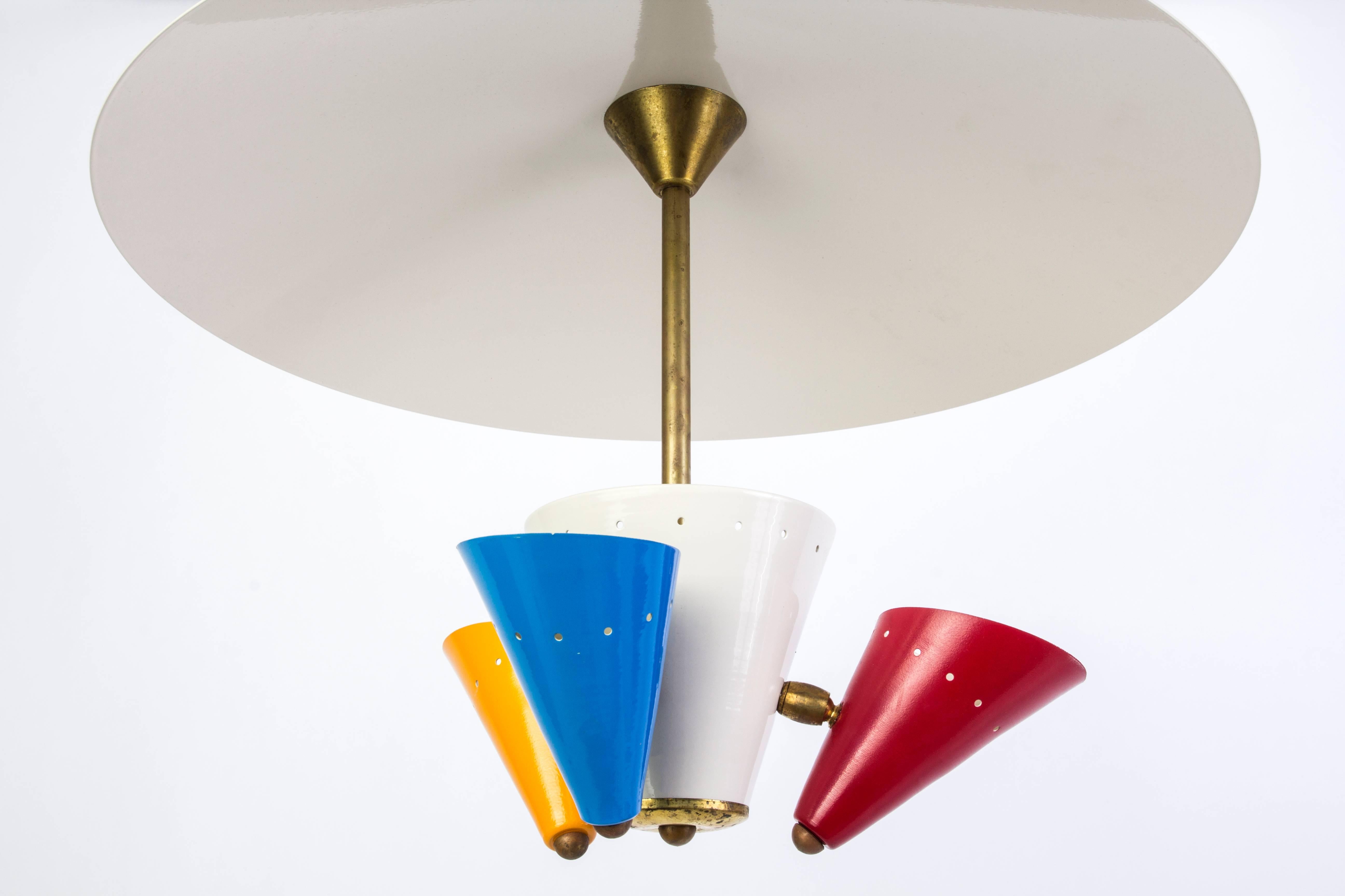 This chic  Mid-Century Stilnovo style chandelier features white enameled center that holds shades in mustard yellow, diabolo red and baby blue. Brass frame and white dome.

Made in Italy

 