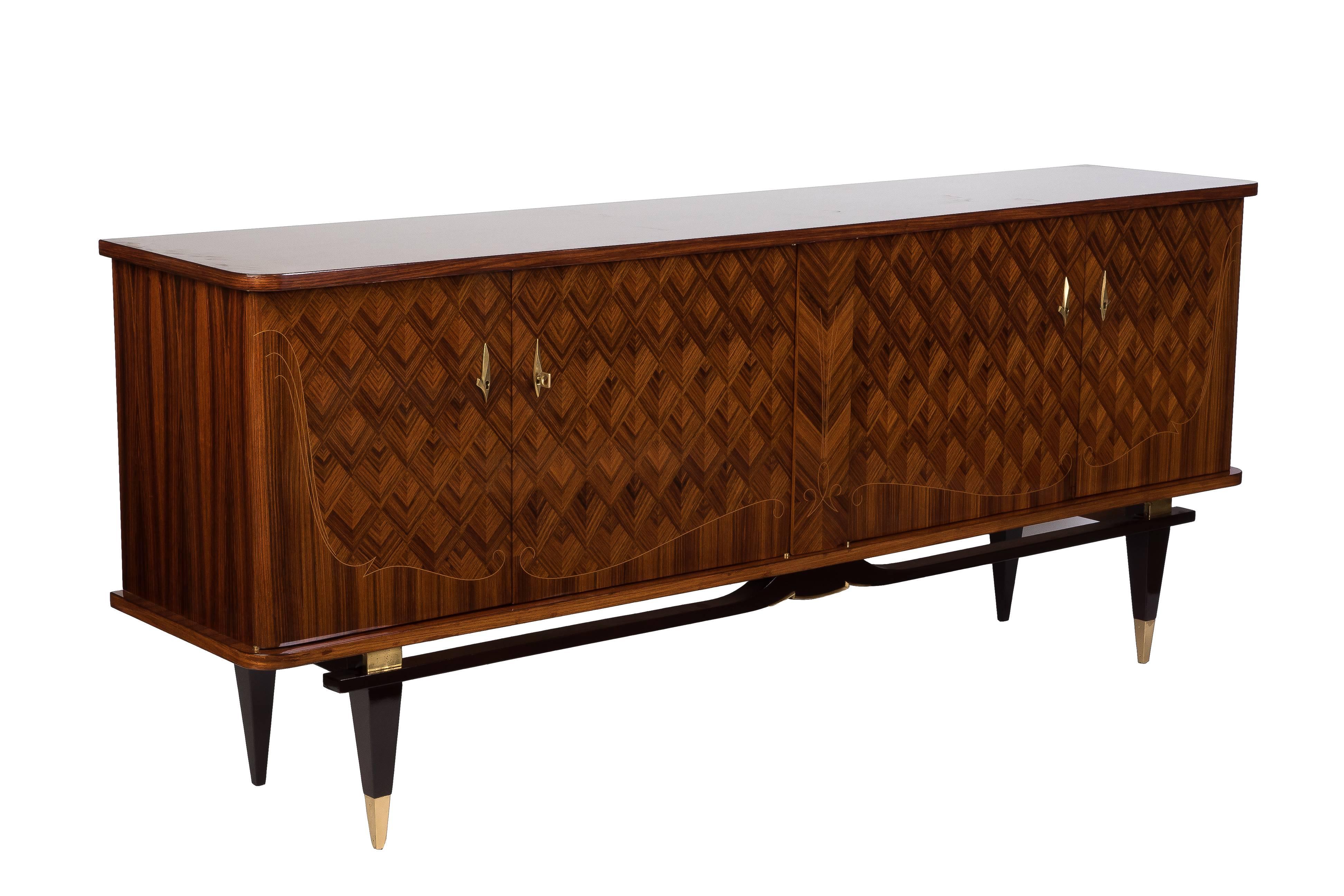 Luxe French Art Deco buffet or sideboard in solid mahogany veneered in exotic Rio palisander marquetry with stained mahogany leg. Hardware in brass. Finished interior in sycamore.

Made in France, circa 1935.