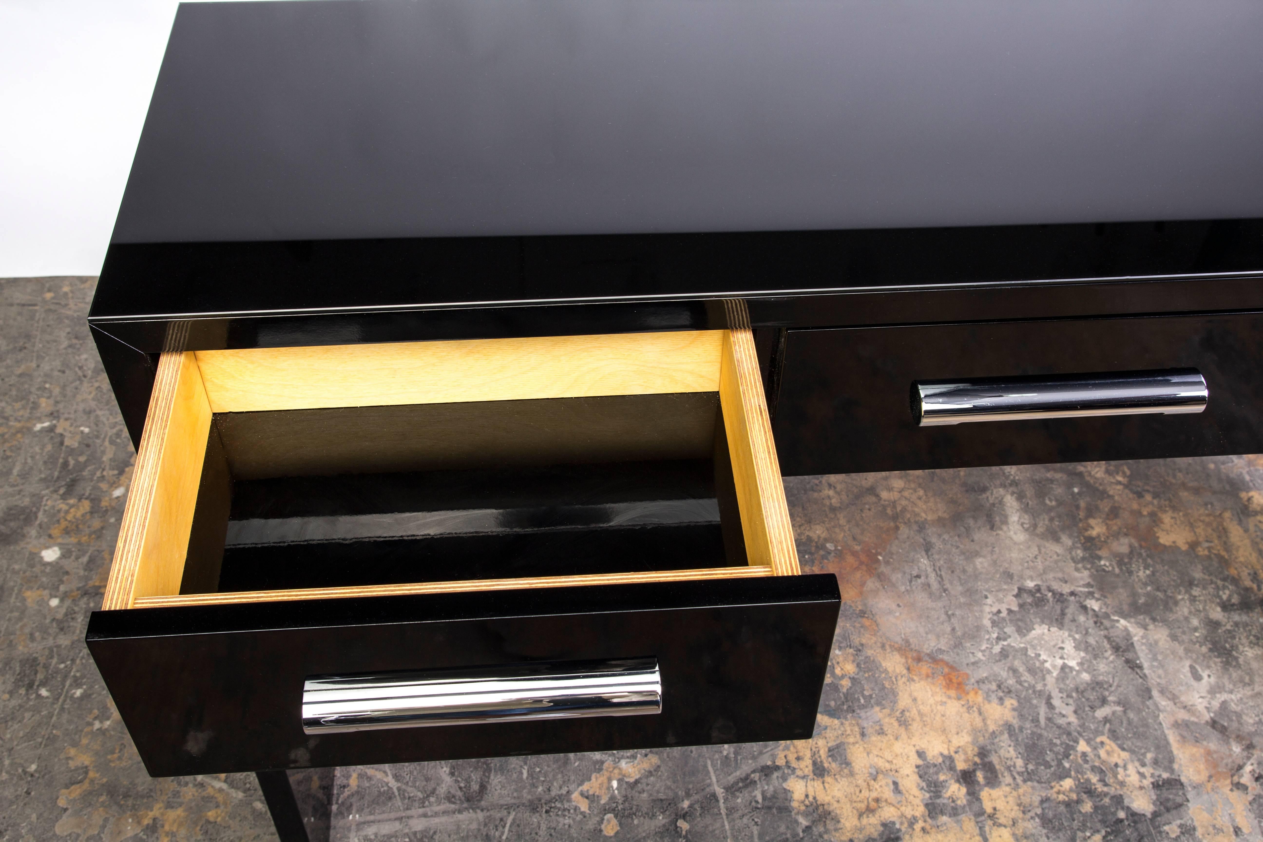 This beautiful Art Deco console was designed in the manner of Bauhaus. It has simplistic design with chrome handles finished and topped with a lacobel plate. Finished in a high gloss black lacquer.