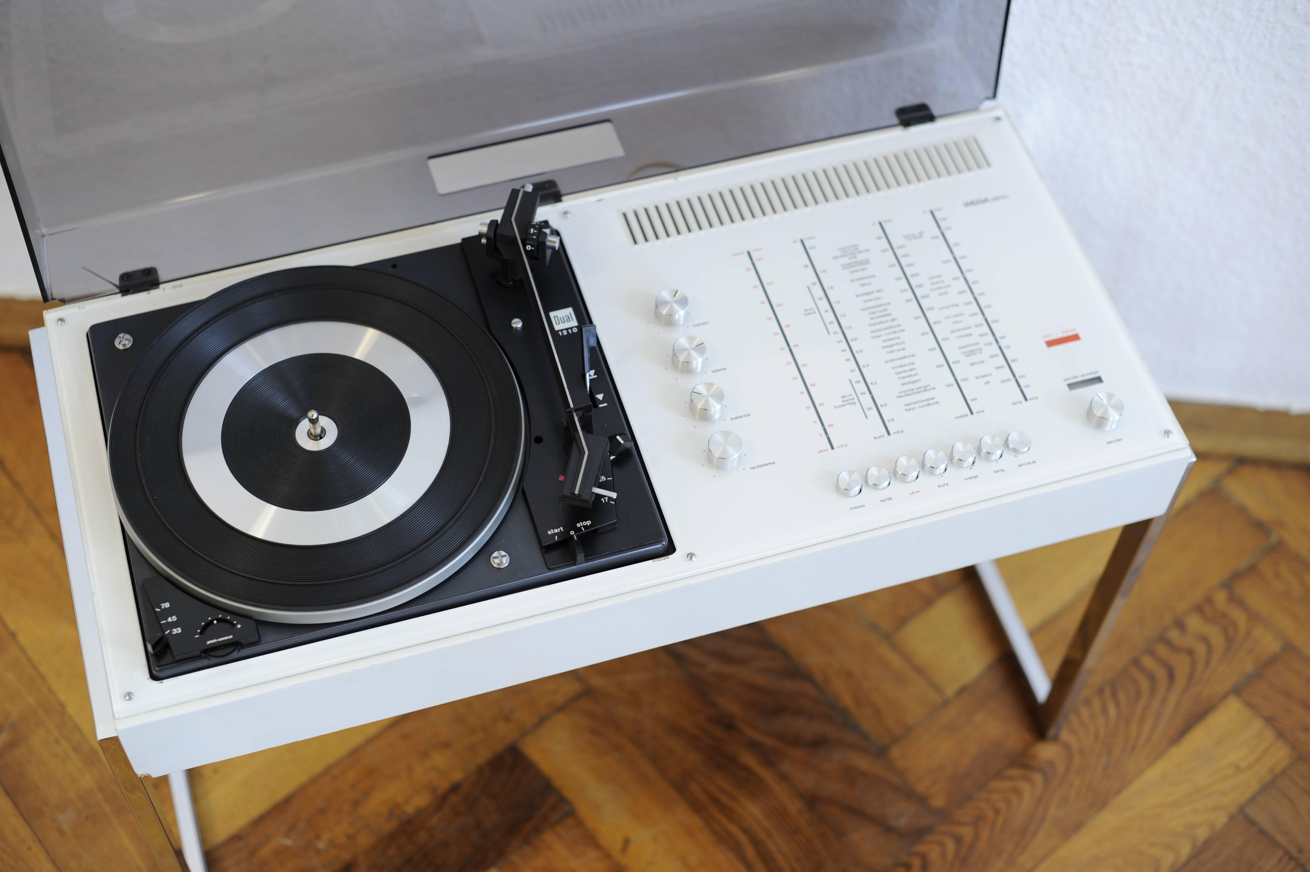 We offer this extremely stylish and cool looking White Wega Studio 3202 L Hifi Record Player Radio Receiver Stereo Equipment on this very cool chrome base stand.
This is definitely the coolest stereo equipment set from the 1970s Panton Eames era we