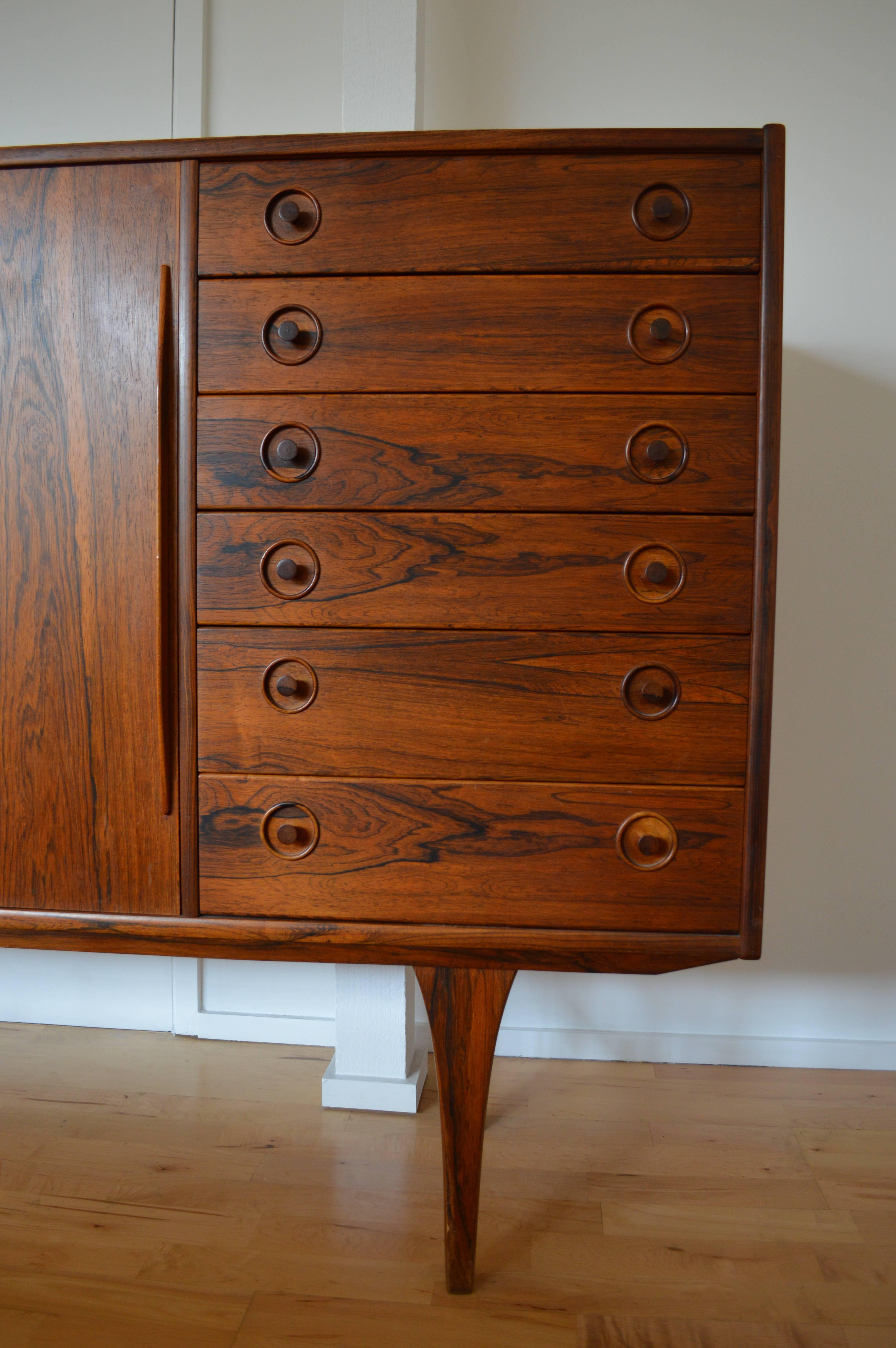 A stunningly beautiful grain on this piece, very much in the style of H.W. Klein but equally of the same age with gorgeous turned handles on the drawers and solid rosewood legs.

Sturdy yet super-stylish, the credenza has six drawers on the right