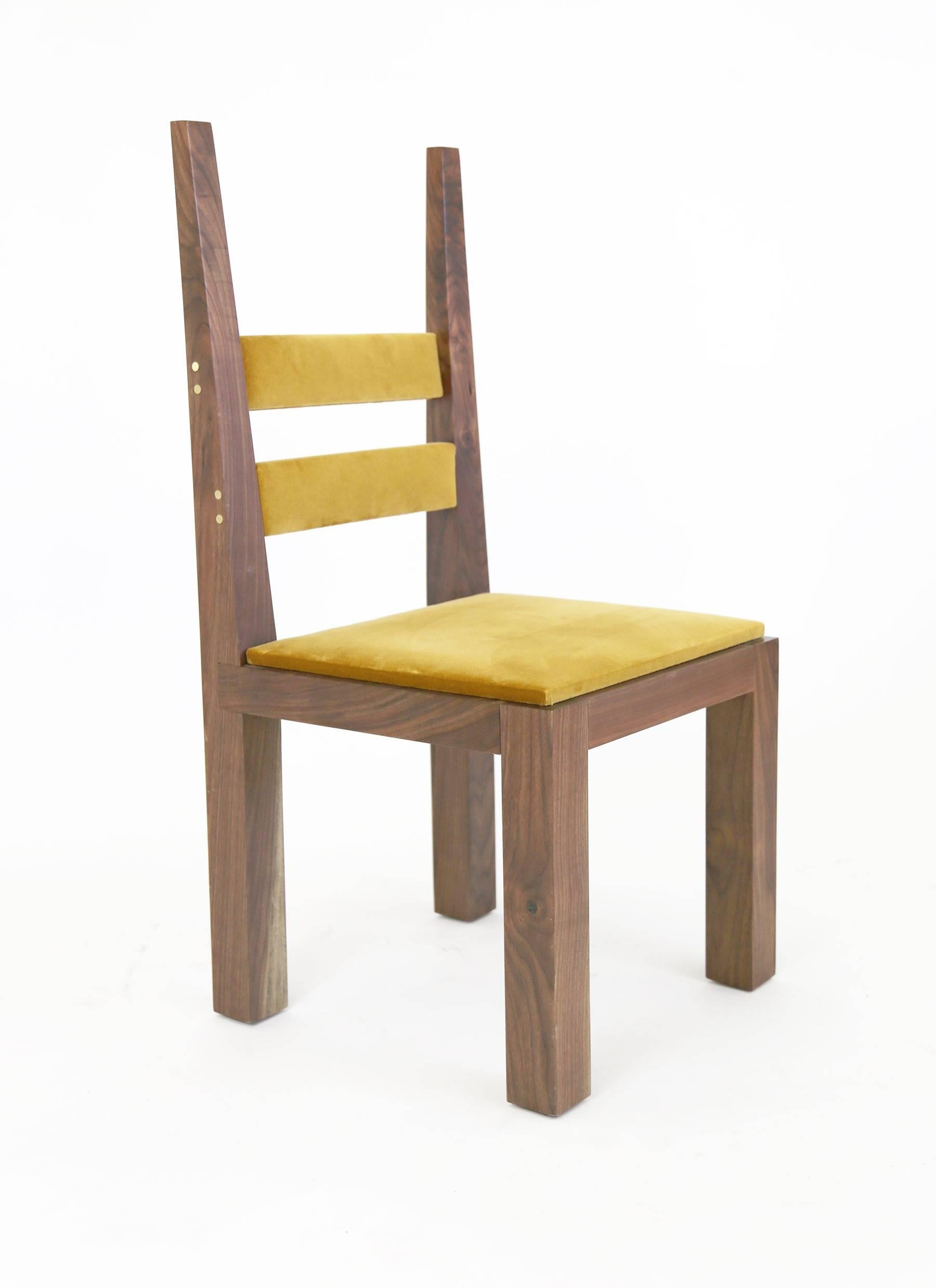 A contemporary dining chair designed and built by Sentient. It has both medieval and modern ideas including heavy legs and seat frame combined with the tapered, angled lines of the tall rear verticals.