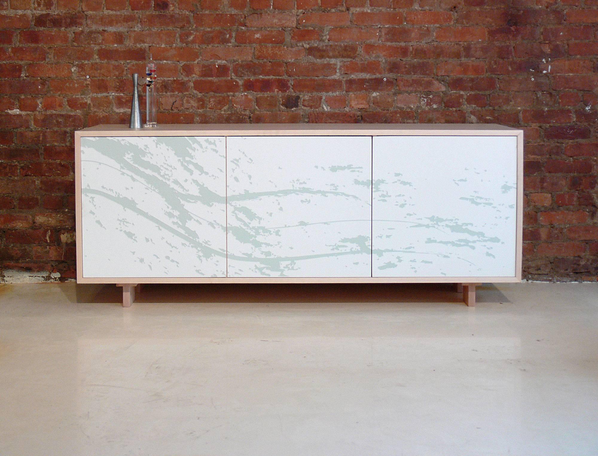This credenza features three doors with laser-engraved custom art with an inlay. The cabinet opens to store anything from stereo equipment to service ware. Inside there is adjustable shelving. The cabinet is made using locally-sourced maple