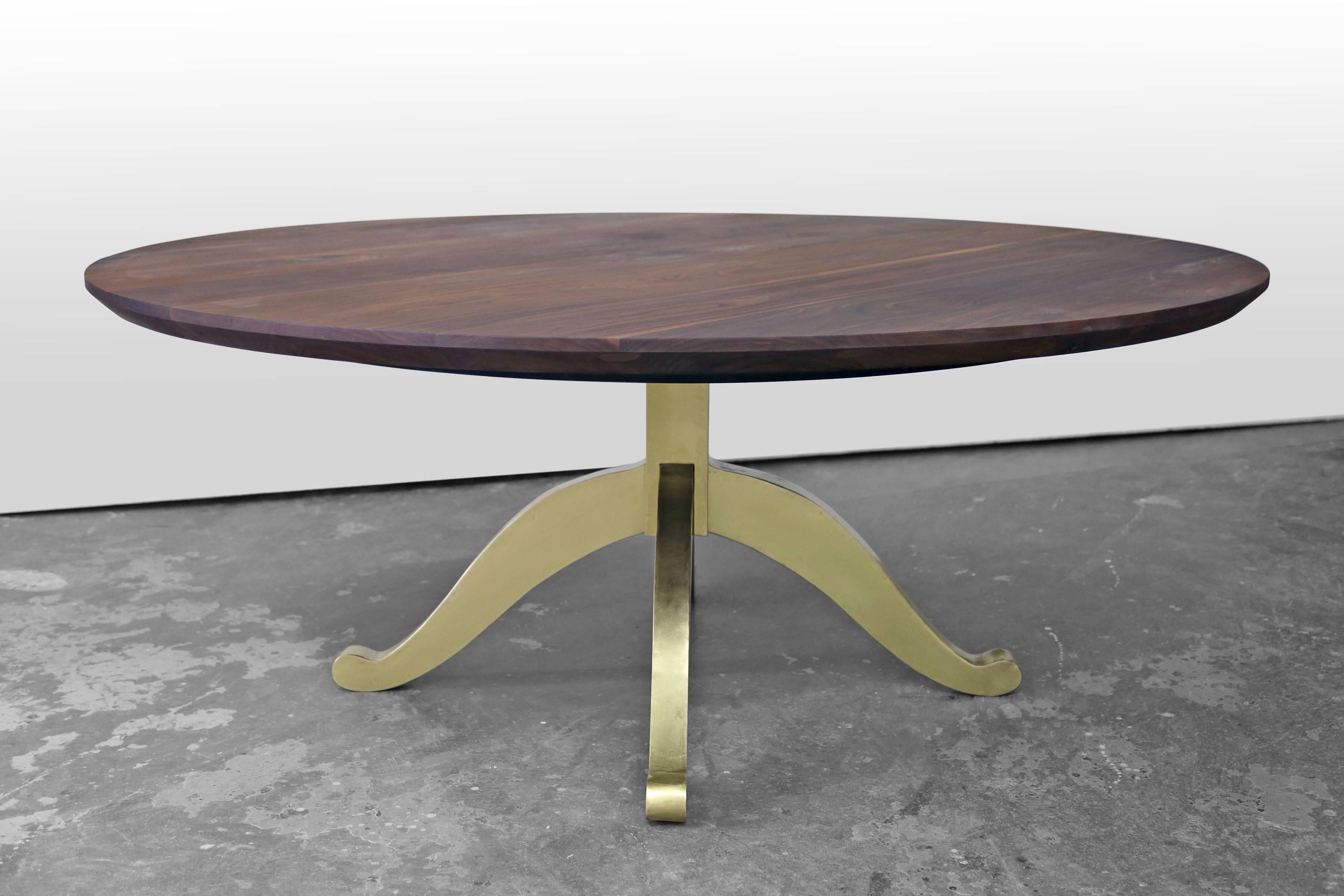 This table design features a large round walnut top and a wishbone pedestal base with a bright brass finish. The top is 76 inches across. We source our walnut from a family owned lumber mill in Pennsylvania and we make each of our tables to order in