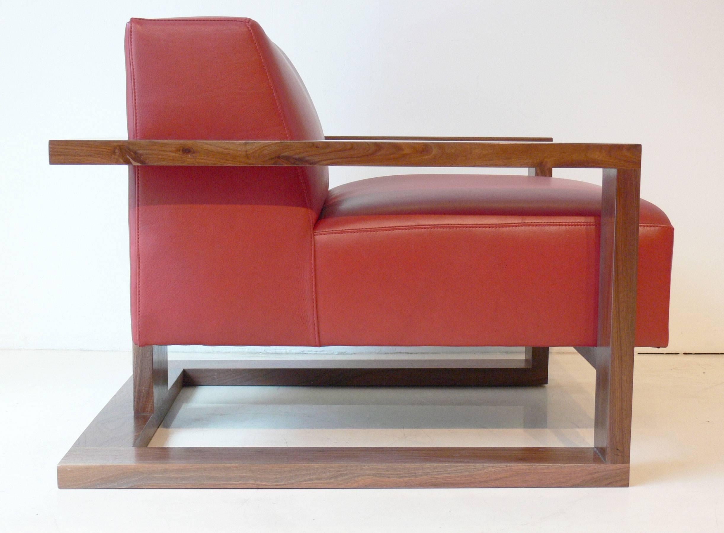 The Caribou lounge chair is a low lounge that features a hardwood exposed frame. It is being offered here upholstered in red leather, however we have options for upholstery. The frame is shown in walnut.