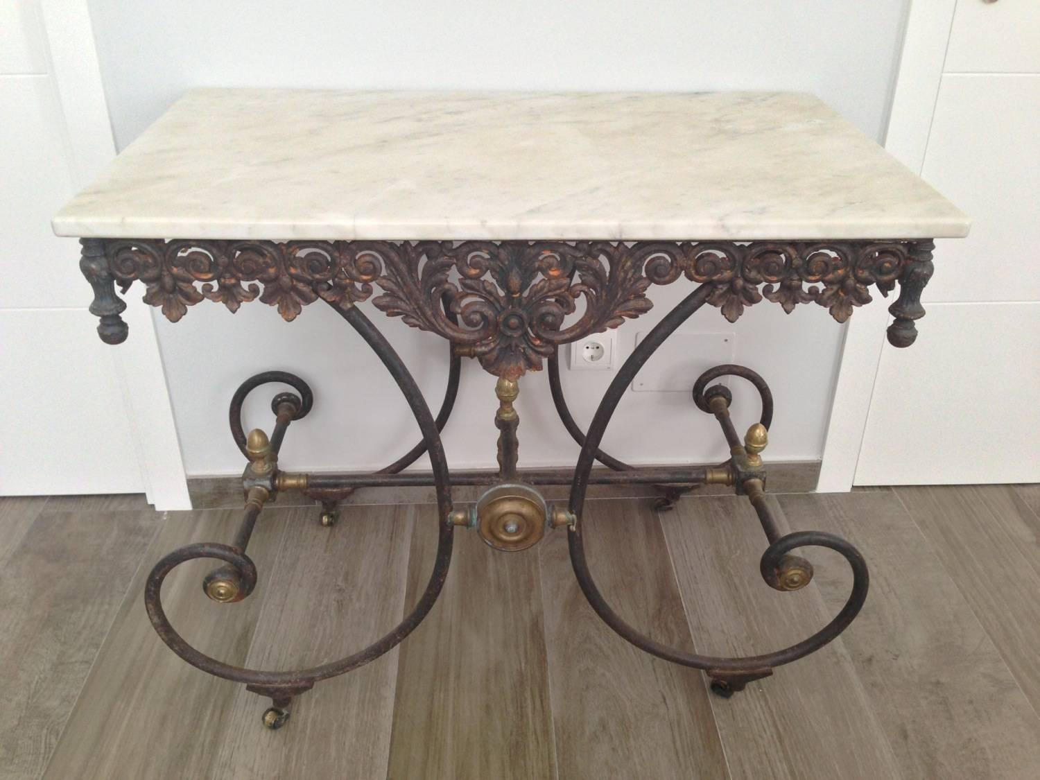 French butchers table from the 19th century, with white marble top, ornate cast frieze and scrolled iron legs. The iron keeps the original patina.

 