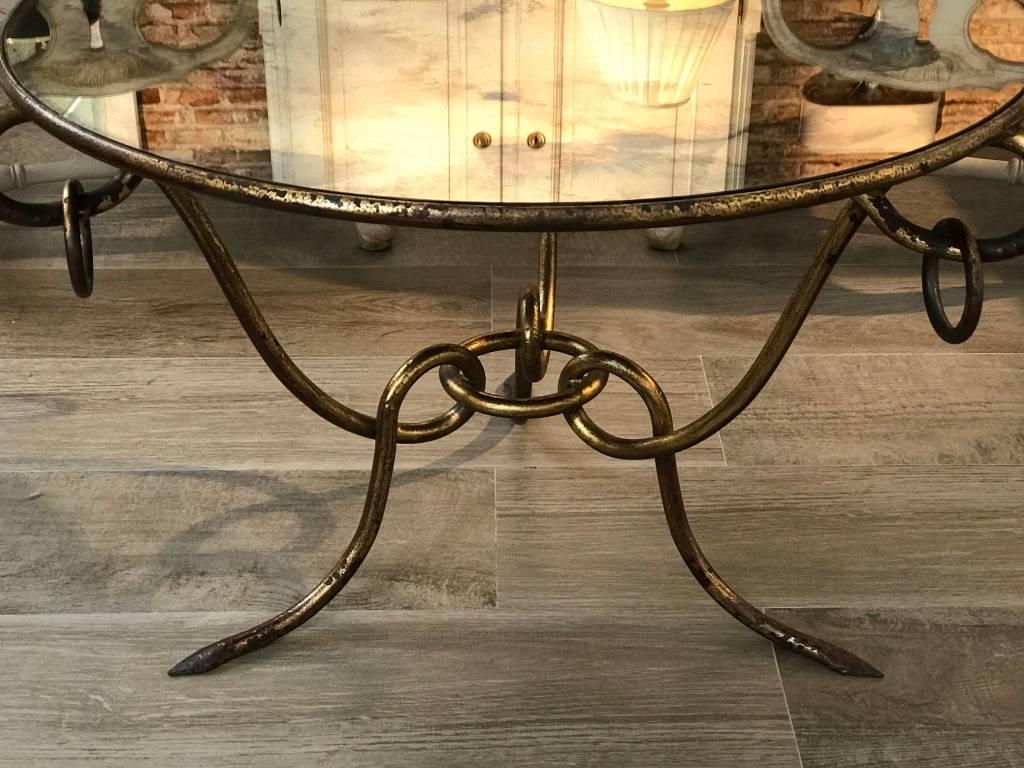 French Mid-Century round gilt iron coffee table with mirrored top and three legs in the shape of a snake, by René Drouet (1899-1993). Beautiful patina. Circa 1940-1950.