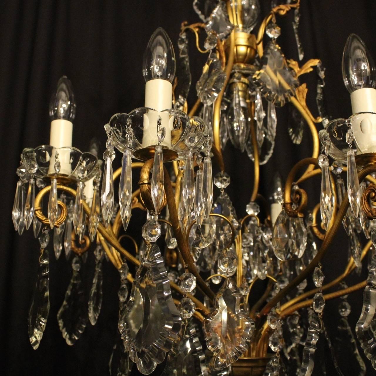 A French gilded cast brass and crystal nine-light birdcage form antique chandelier, the eight reeded scrolling arms with glass bobeche drip pans, issuing from an foliated cage form interior with a single inverted light fitting and a leaf canopy with