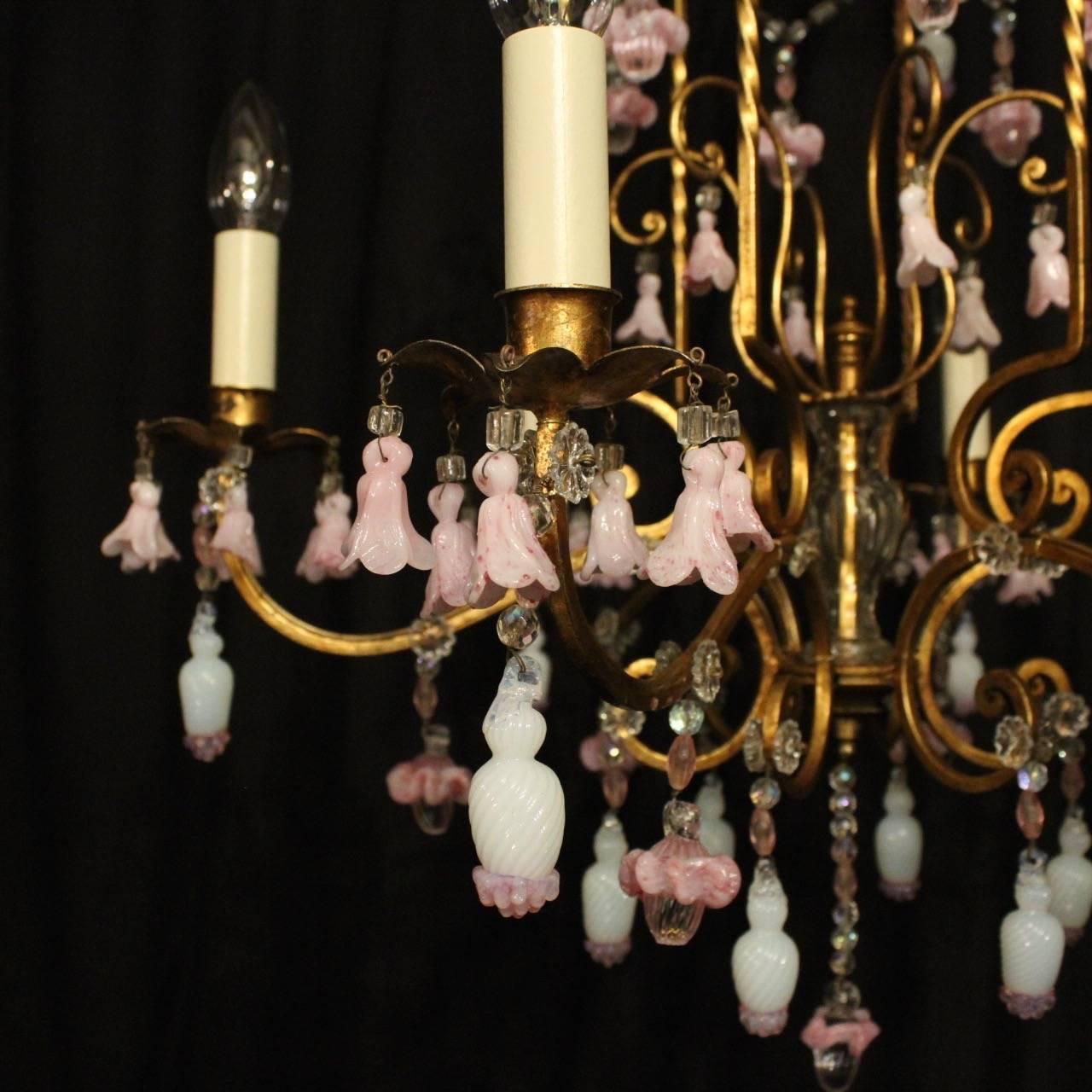 A decorative Italian gilded and crystal six-light birdcage form chandelier, the square gauge scrolling arms with sectional leaf bobeche drip pans, issuing from an cage form interior with a glass baluster column and scrolling canopy, decorated
