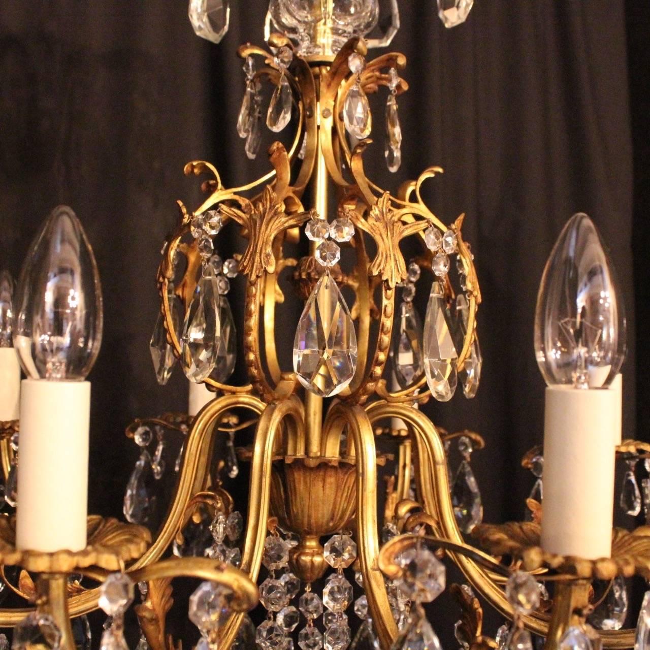 An Italian gilded bronze and crystal eight-light antique chandelier, the acanthus leaf clad scrolling arms with sectional leaf bobeche drip pans, issuing from a central open cage form interior with glass baluster column top and Acanthus leaf