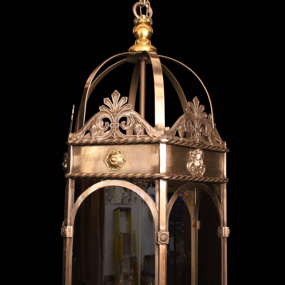 A monumental French Eight light brass and polished wrought iron hexagonal antique lantern, the six glass panels held within a decoratively cast barley twist framework with 8 internal double tiered light fittings, having decorative pierced central
