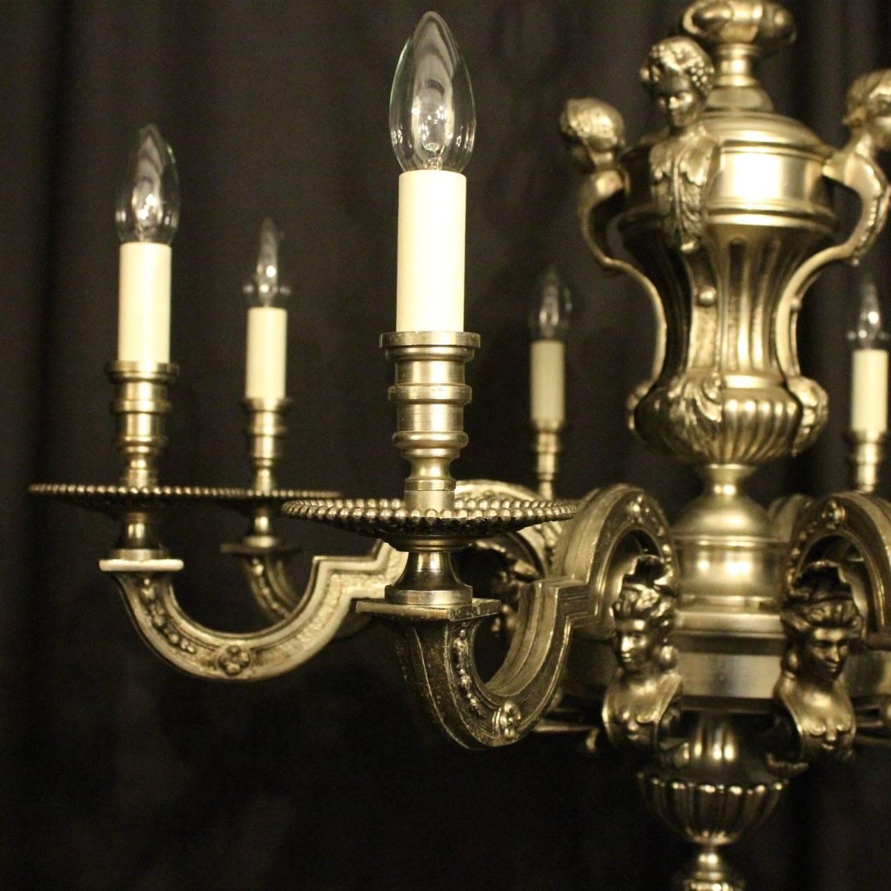 A French silver gilded cast bronze eight-light antique chandelier in the manner of Andre Charles Boulle, the square gauge scrolling arms with ornate bobeche drip pans and candle sconces, issuing from a pierced central urn stem with four female