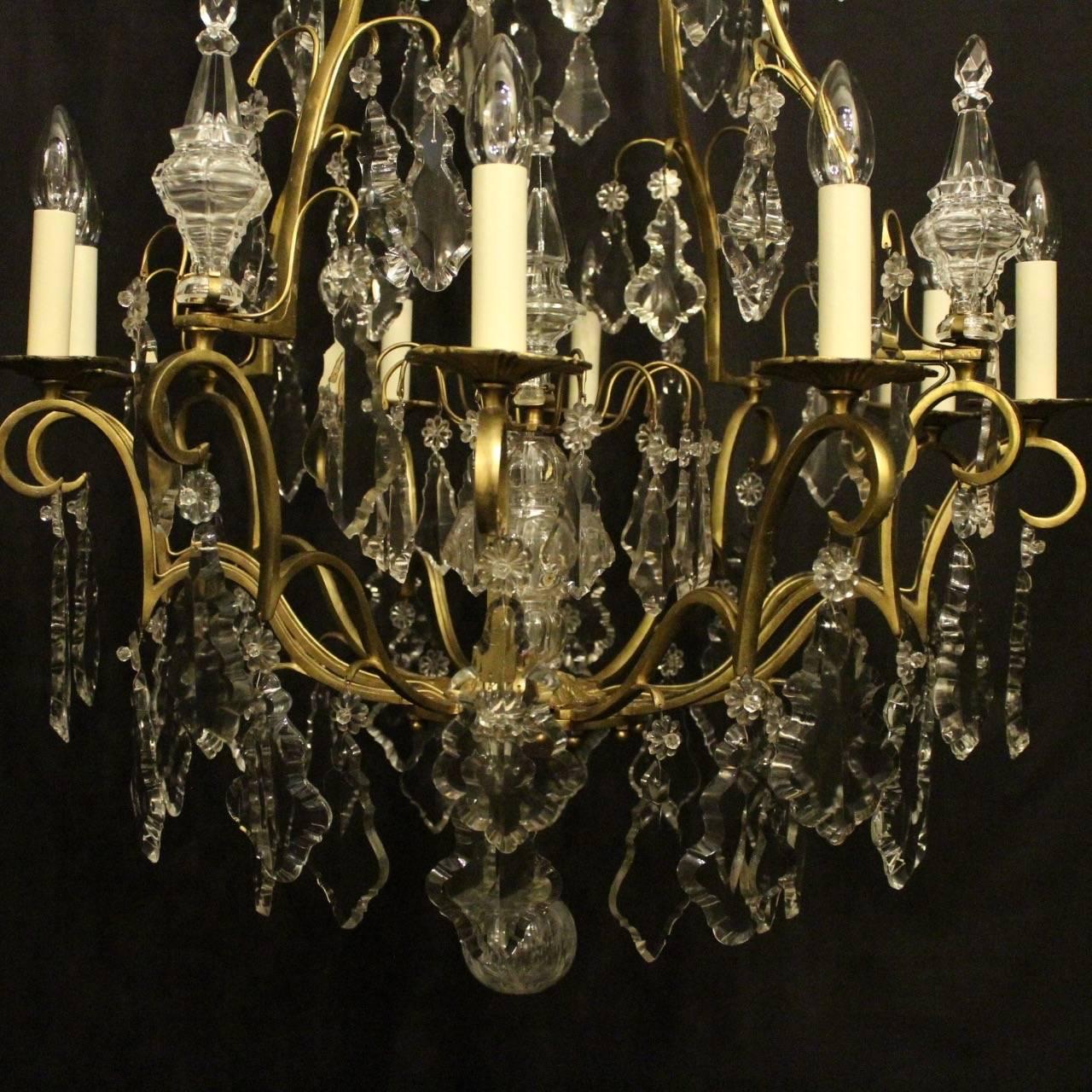 A French large gilded cast brass and crystal eight-light birdcage form antique chandelier, the square gauge scrolling arms with reeded circular bobeches drip pans, issuing from an foliated cage form interior with a large prismatic spike and an