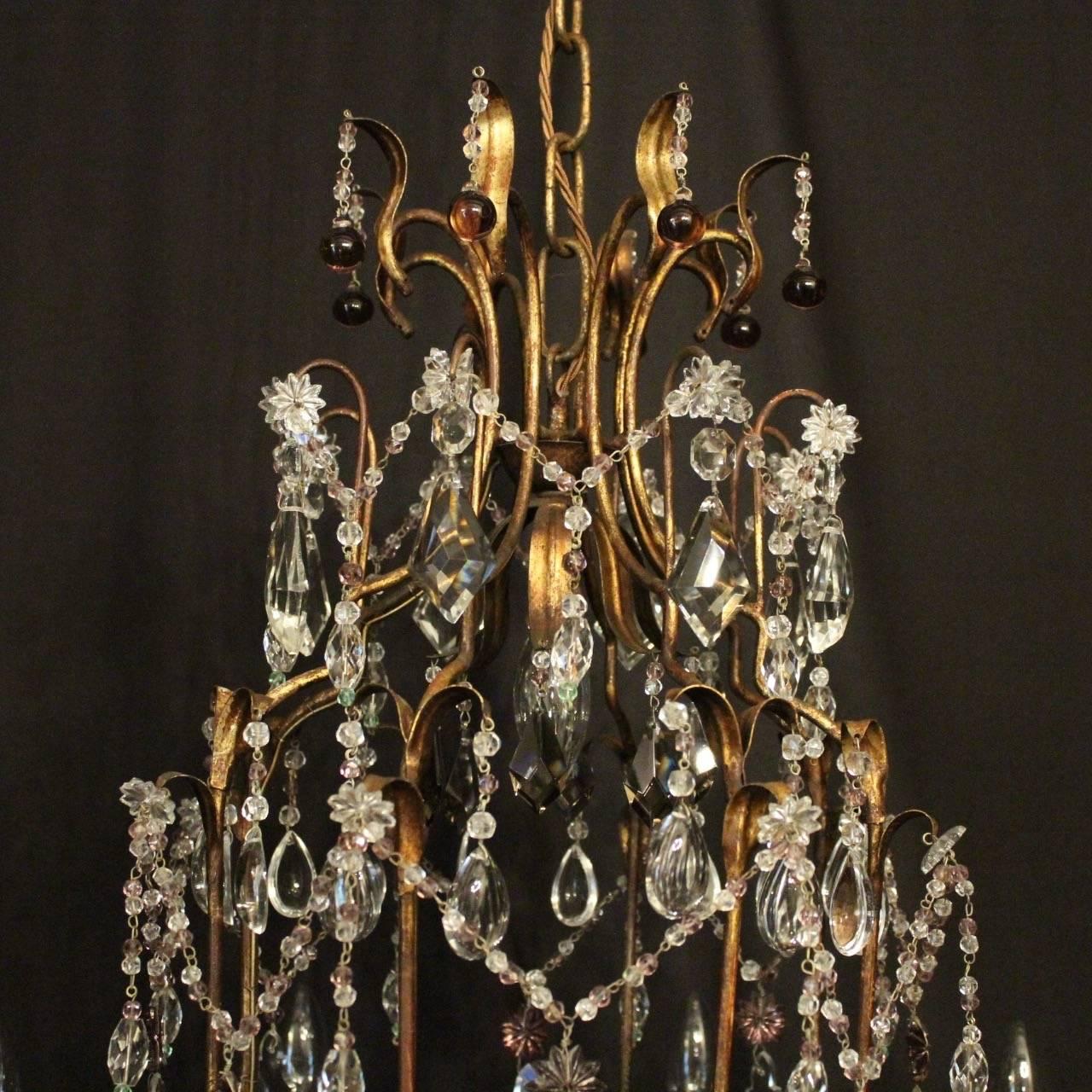 An Italian gilt and crystal eight-light birdcage form antique chandelier, the leaf scrolling arms with circular leaf bobeche drip pans, issuing from an cage form interior and ornate scrolling canopy, decorated overall with lattice and swaged clear