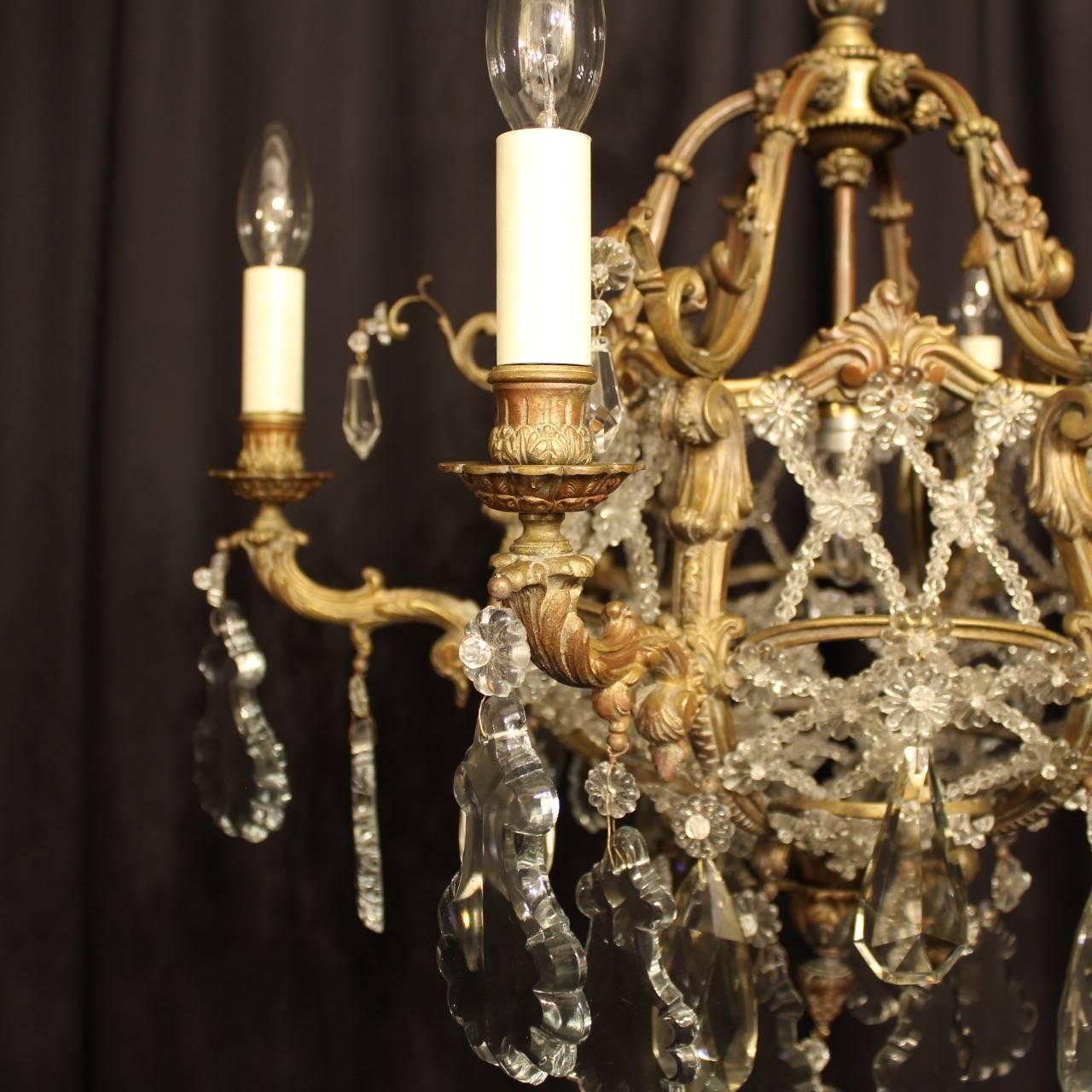 A French gilded cast bronze and crystal seven-light birdcage form antique chandelier, the six scrolling arms with foliated bobeche drip pans and bulbous candle sconces, issuing from a cage form interior decorated with lovely cut-glass lattice work