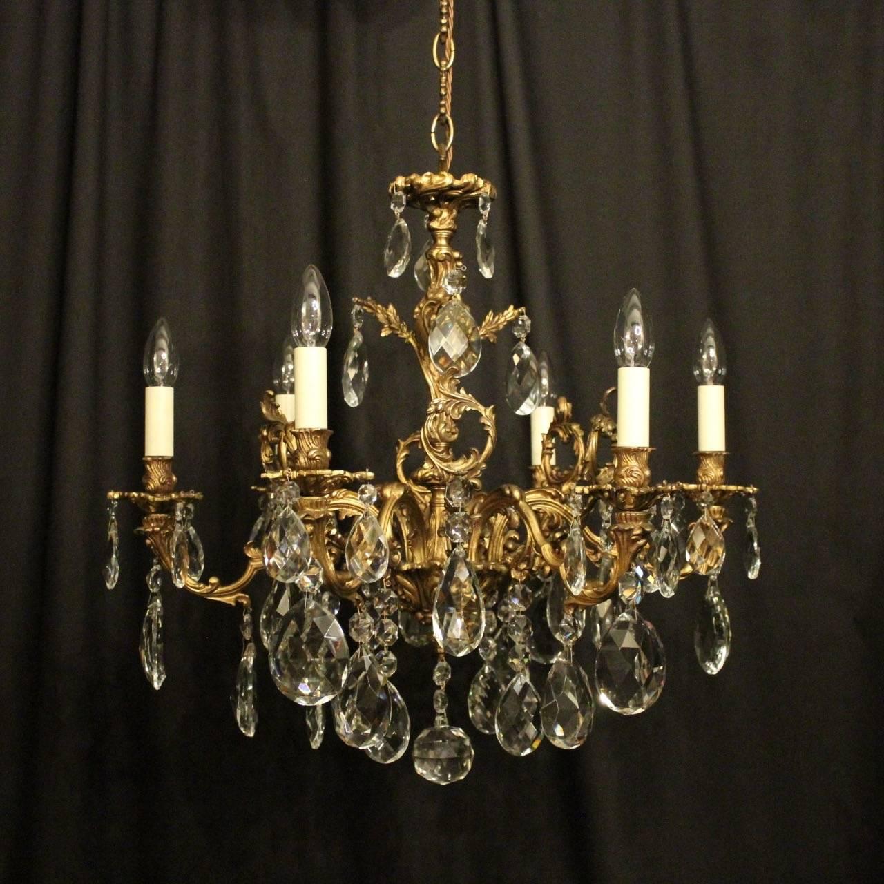 An Italian gilded cast bronze and crystal six-light antique chandelier, the leaf scrolling arms with leaf bobeche drip pans and bulbous candle sconces, issuing from a foliated central column with ornate scrolling leaf pierced outcrops, decorated