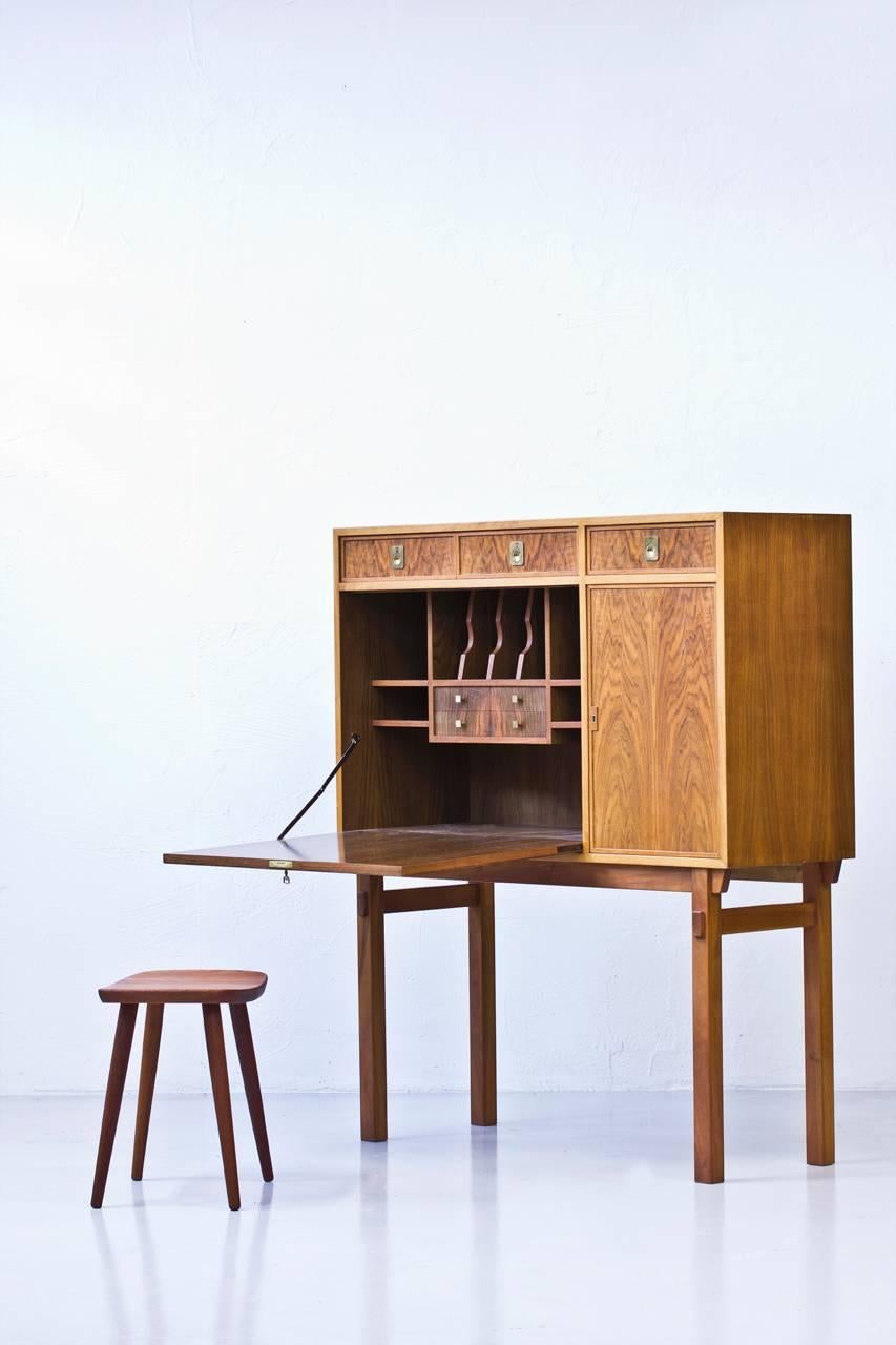 Cabinet with built in secrétaire and bar designed and produced in Sweden during the 1960s. High quality piece most likely done by a skilled cabinet maker. Walnut veneer in- and outside standing on solid mahogany legs. Solid mahogany in all the