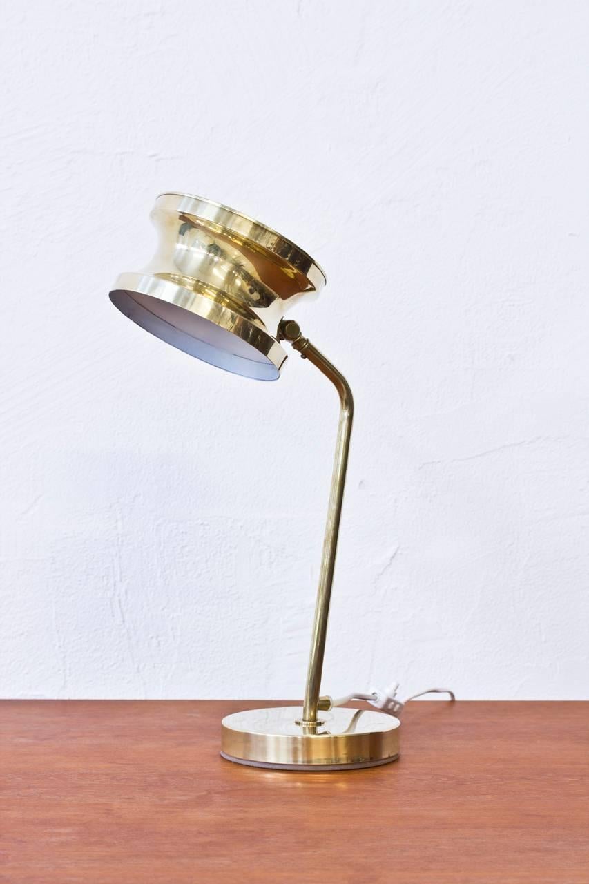 1960s table lamp in solid polished brass by Swedish company Tyringe Konsthantverk. Adjustable shade. New white electric chord with light switch. Very good original condition with light wear and age related patina. Signed.
  