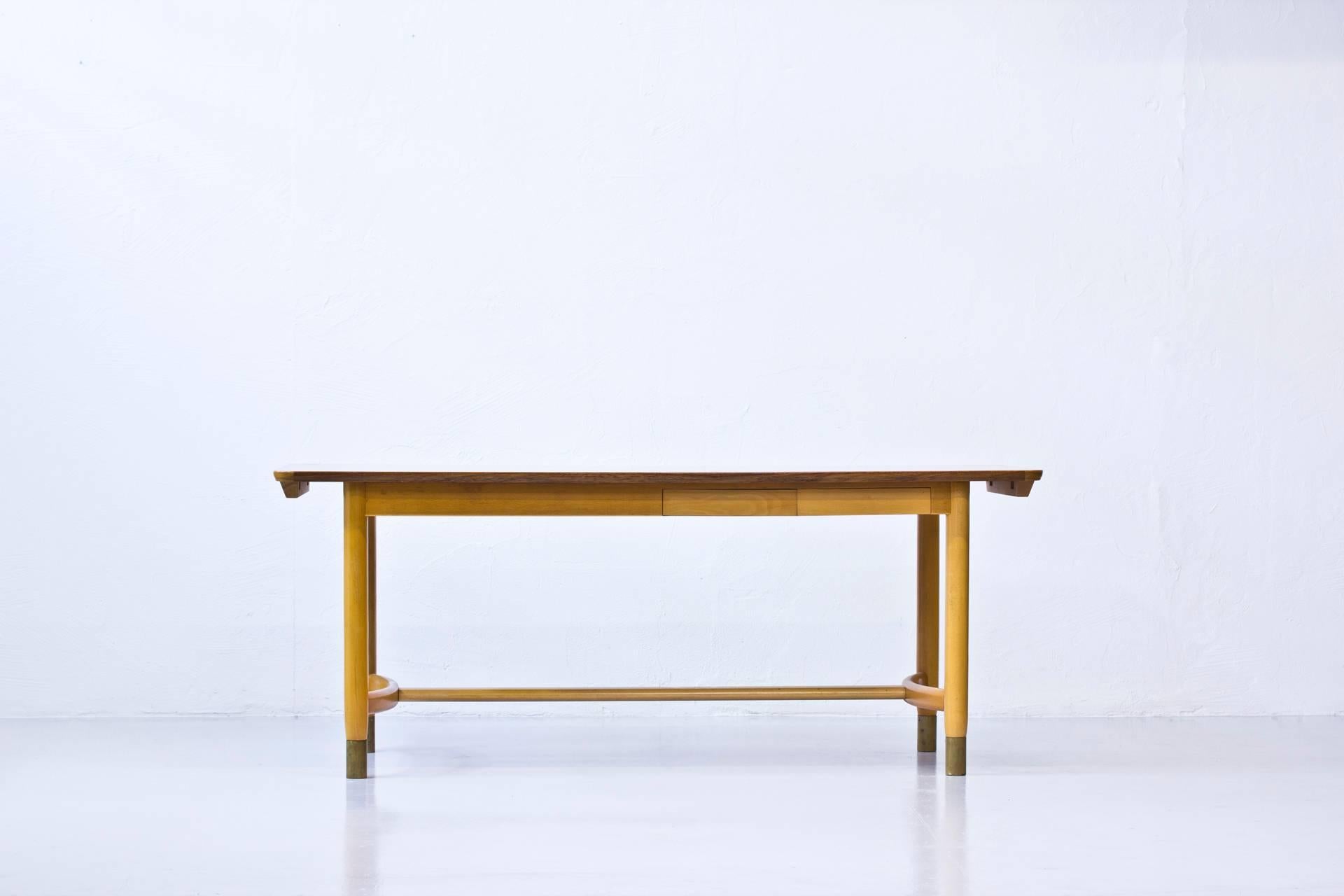 Unique dining table designed by Swedish interior architect Ralph Alton for the office at Ostervala Mobelfabrik in Sweden. The table was also produced at Ostervala Mobelfabrik. Solid beech frame with brass endings. Teak table top with two Dutch style