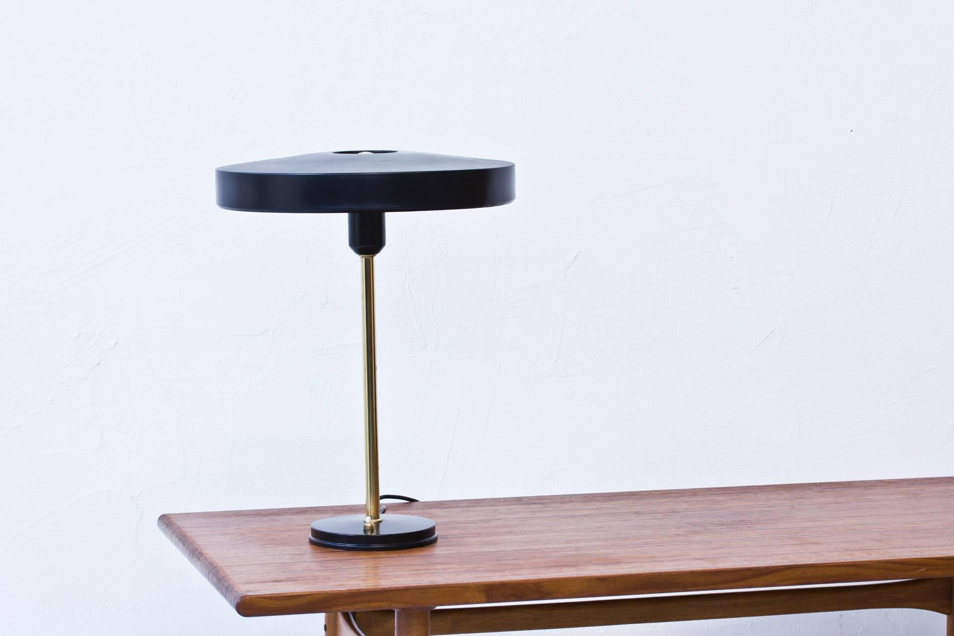 Table lamp designed by Louis Kalff produced by Phillips in the Netherlands during the 1950s. Black lacquered metal and polished brass. Light switch on the base in working order. Excellent condition with few signs of wear and patina.
 