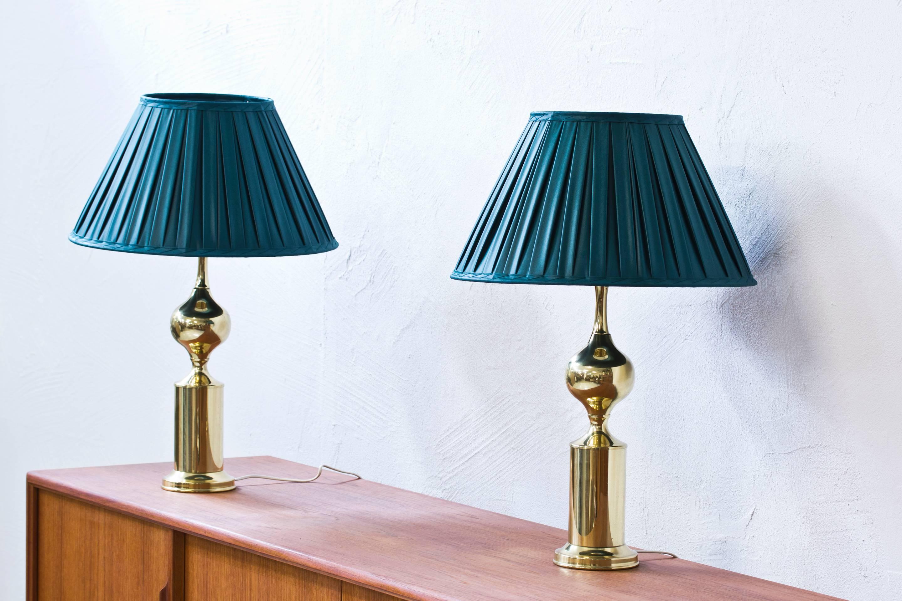 Pair of polished brass table lamps produced by Swedish company Aneta during the 1960s. With hand-sewn pleated silk shades in a dark green color. Light switch on the fixture in working condition. New electricity. Price for the pair.
 