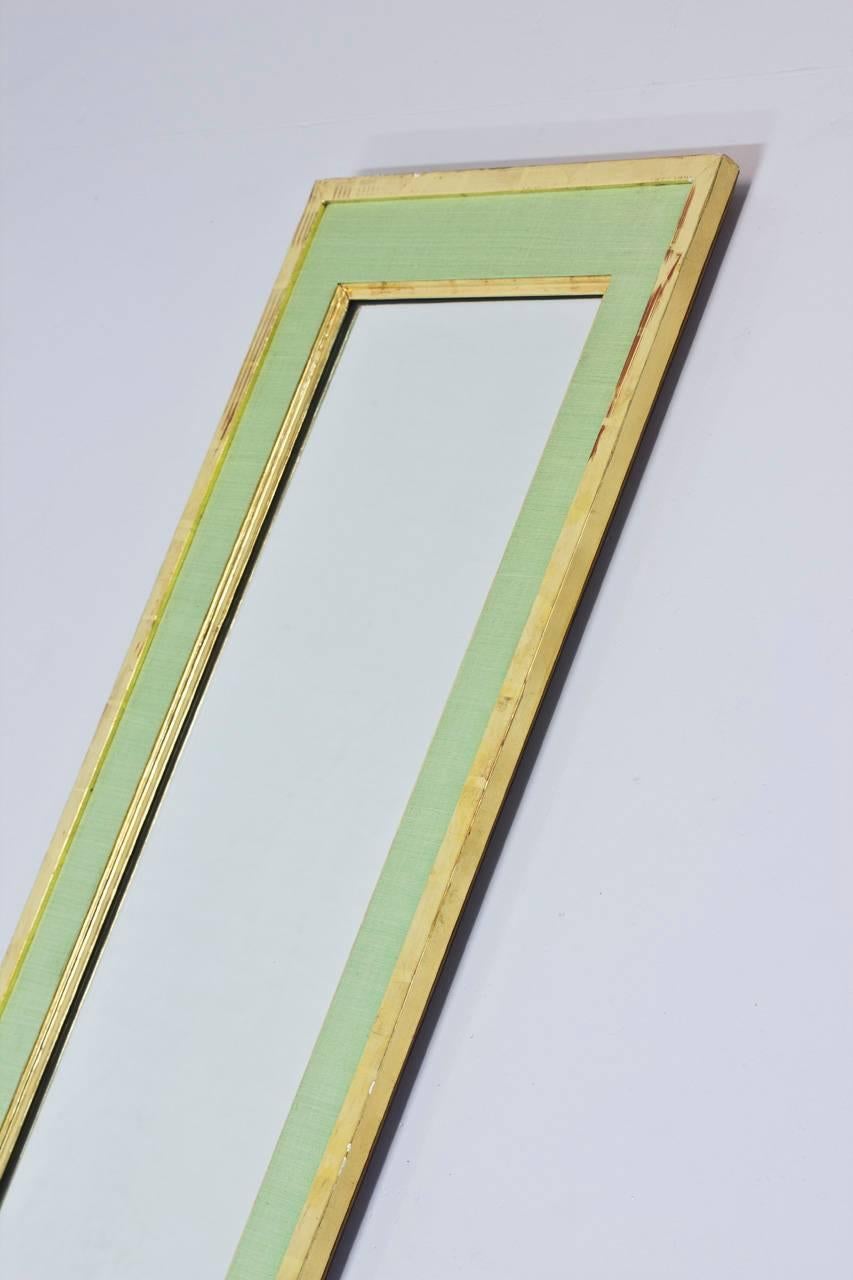 Mirror produced by Firma Svenskt Tenn during the 1940s. Attributed to their founder Estrid Ericson. Green silk with gilded framing. Rare long version. Very good condition with minor restorations to the frame.
 