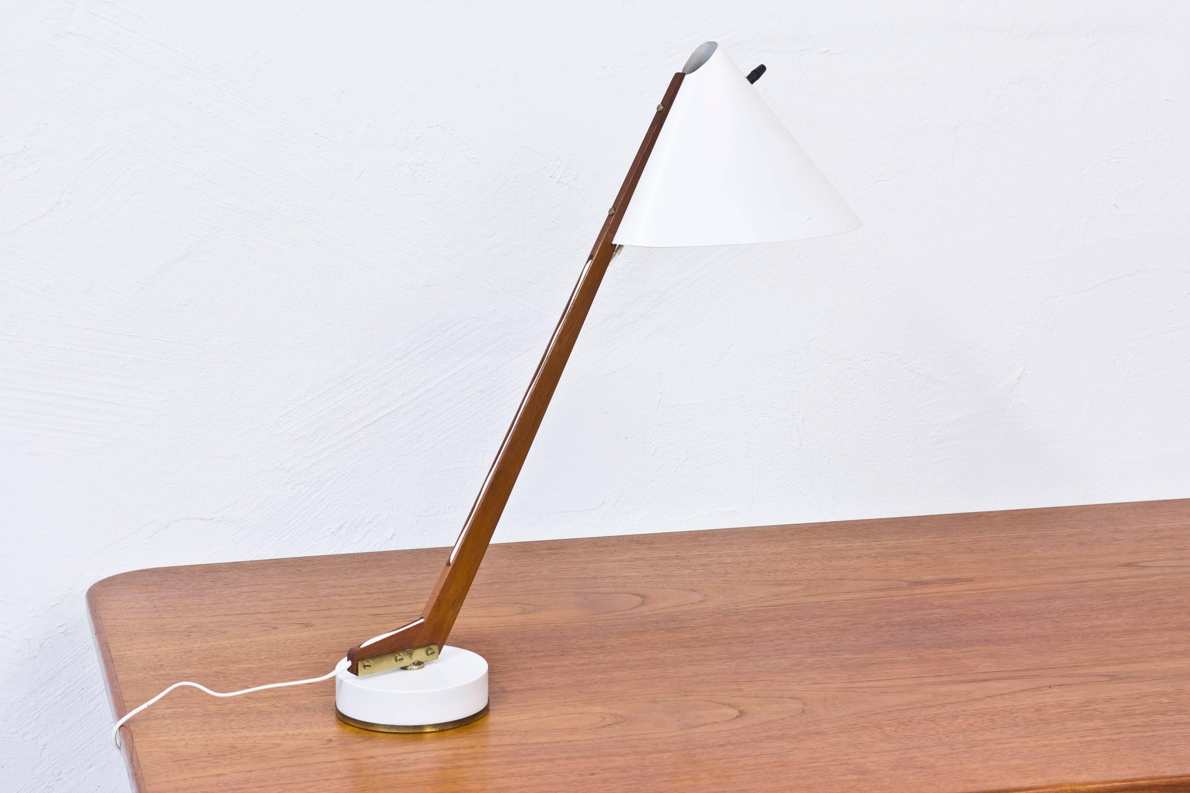 Table lamp model B 54 designed by Hans Agne Jakobsson. Produced by his own company in Markaryd, Sweden during the 1950s. Solid teak stem attached to a white lacquered and brass base. shade Lacquered in white with brass detail. Original turning light