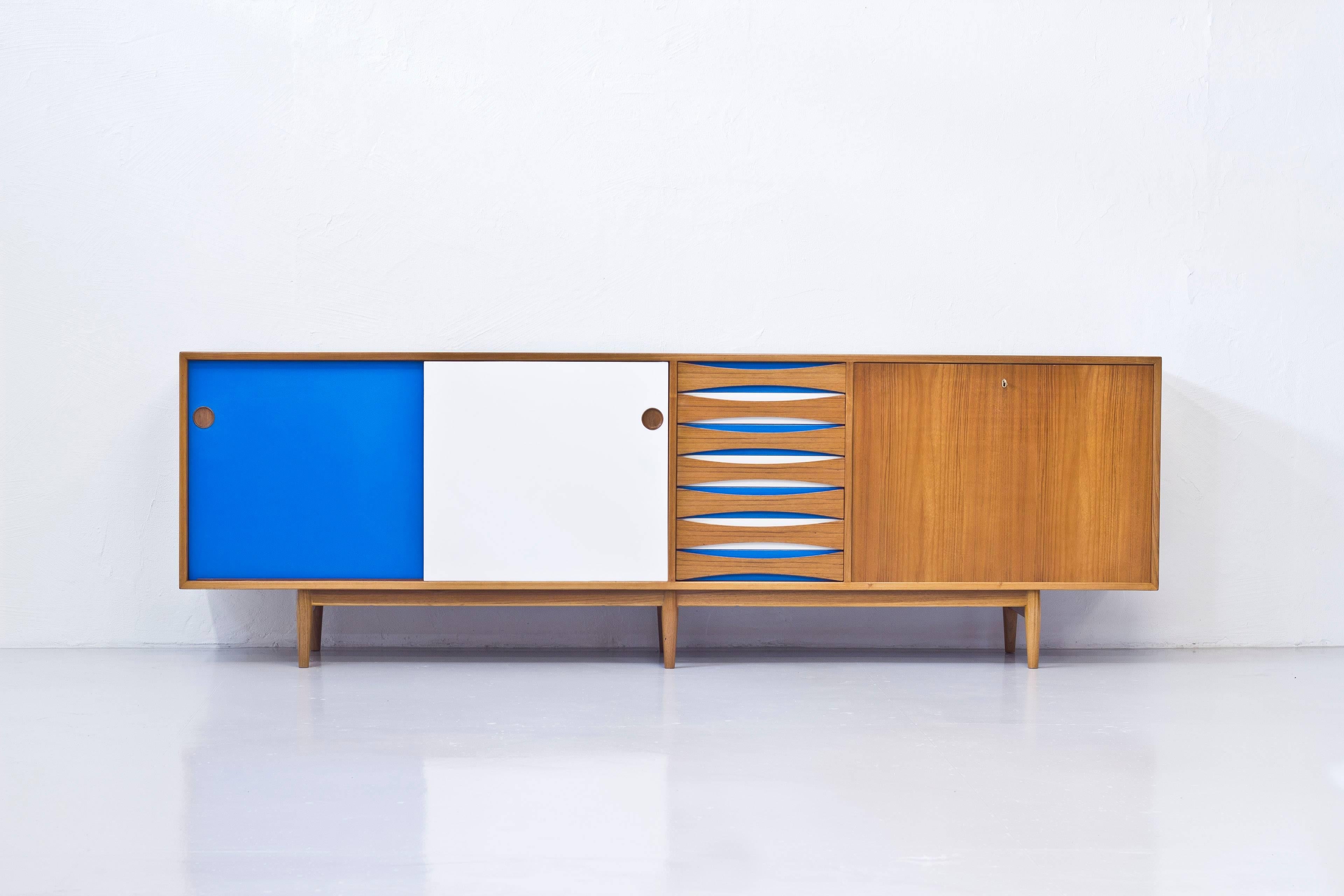 Very rare sideboard model 29A designed by Arne Vodder. Produced in Denmark by Sibast Furniture during the 1950s. Teak and doors/drawers with white and blue formica. Bar cabinet inside on the right with black formica. Veneered with teak on the