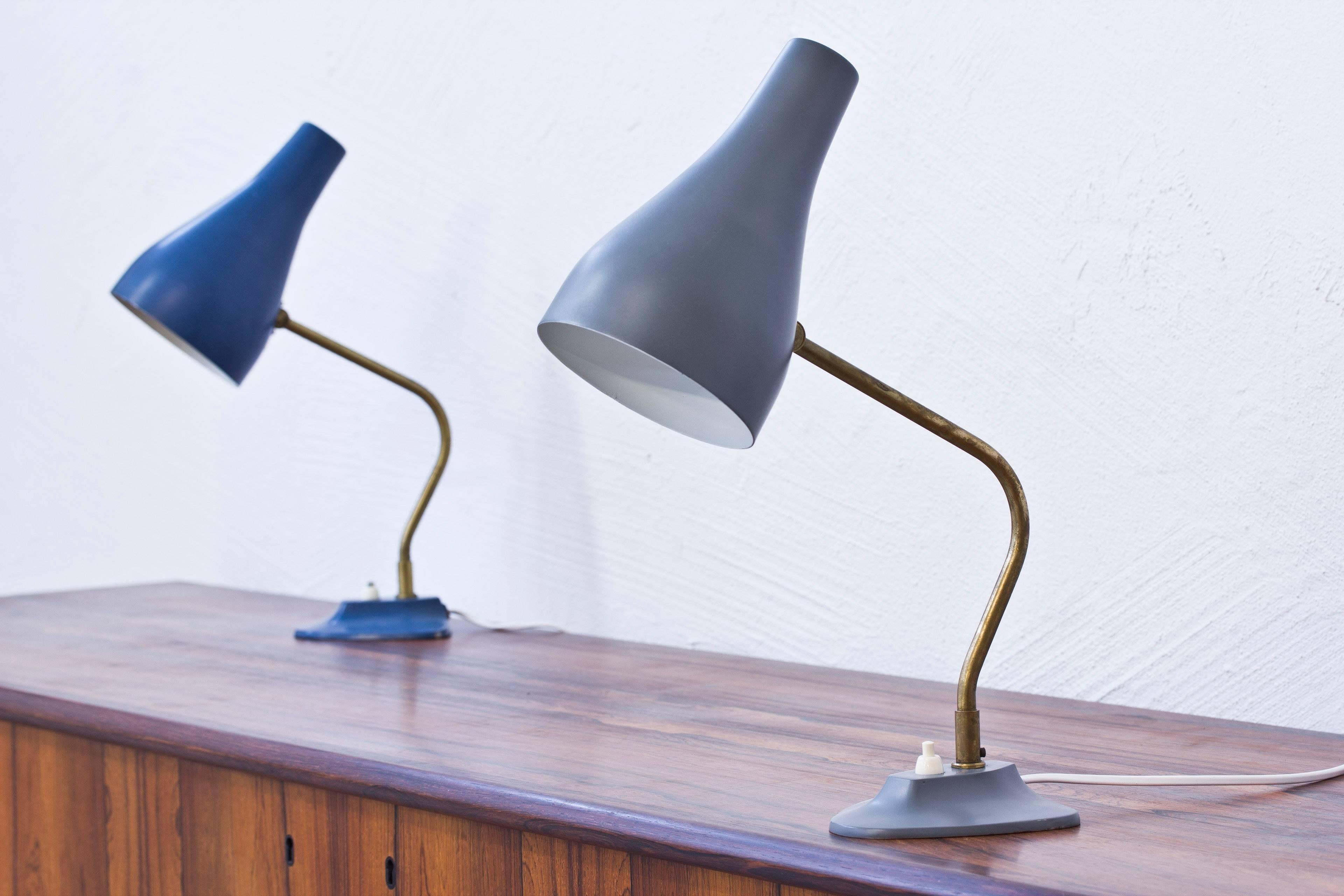 Table lamps produced in Sweden by ASEA. Brass stems with base and shade in painted metal. Adjustable shade and lamp rotating on an axis from the base. Light switch on the base in working order. Very good condition with age related wear and patina.