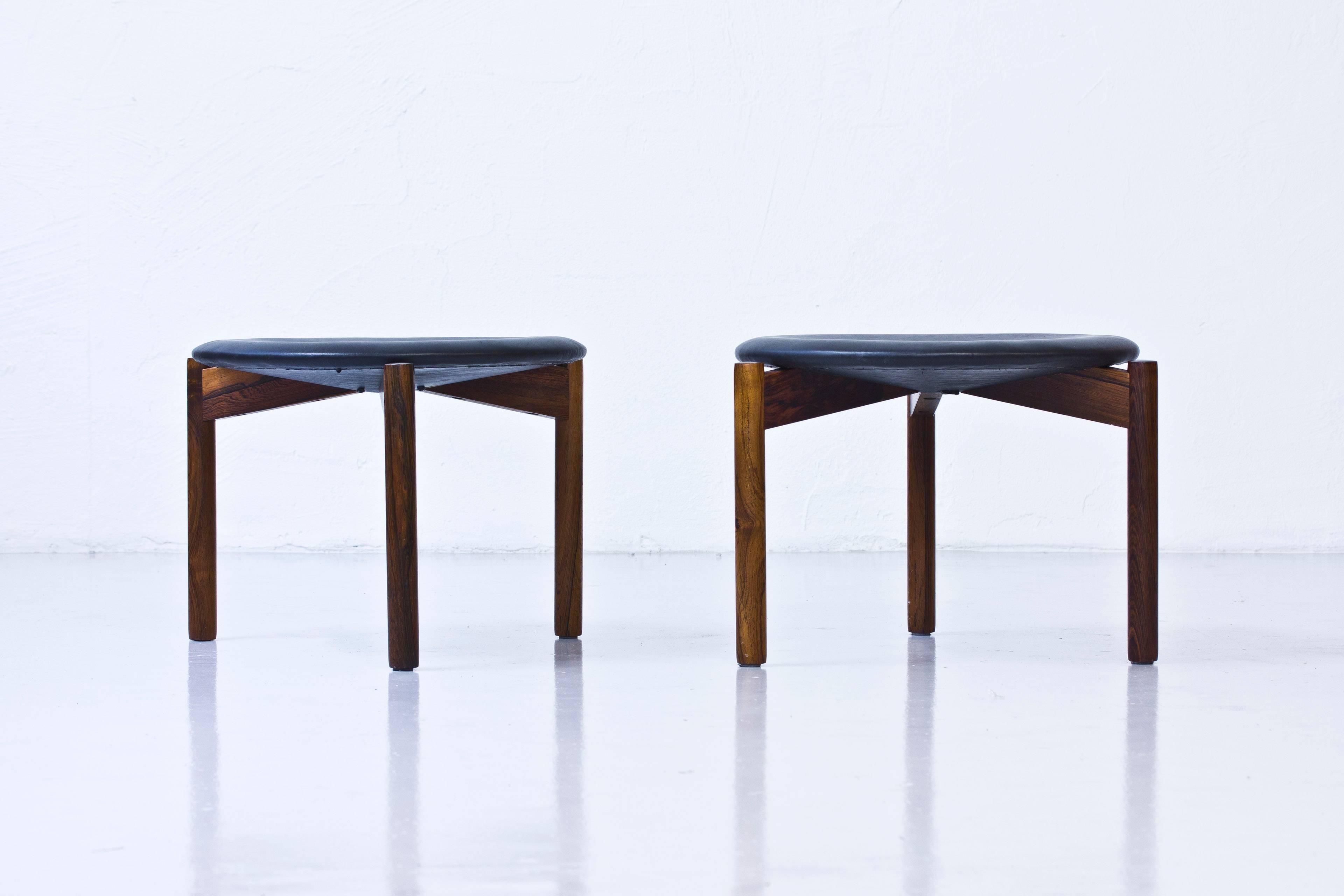 Very rare pair of stools deigned by Uno and Osten Kristiansson. Produced by Luxus in Vittsjo, Sweden during the 1960s. Made from solid palisander wood. Recently reupholstered with new padding and black leather. Excellent condition with very few